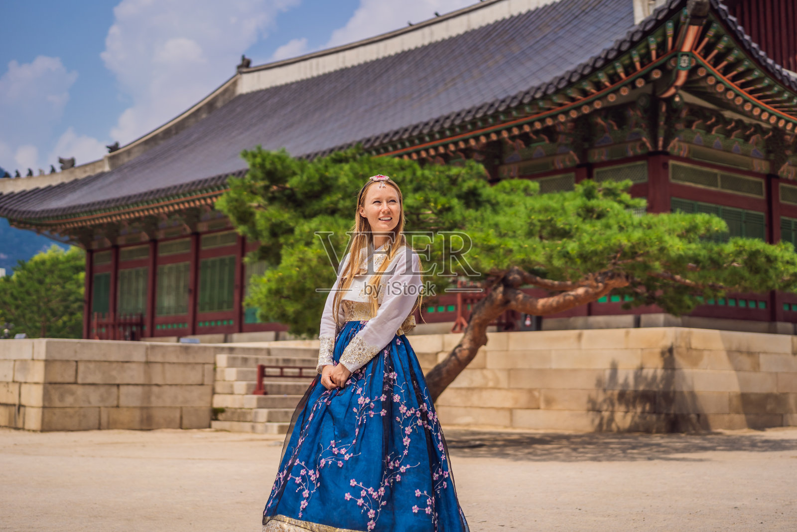 身穿韩服的年轻白种女游客在韩国宫殿。韩国旅游概念。国家韩国的服装。为游客提供的娱乐——试穿韩国民族服装照片摄影图片