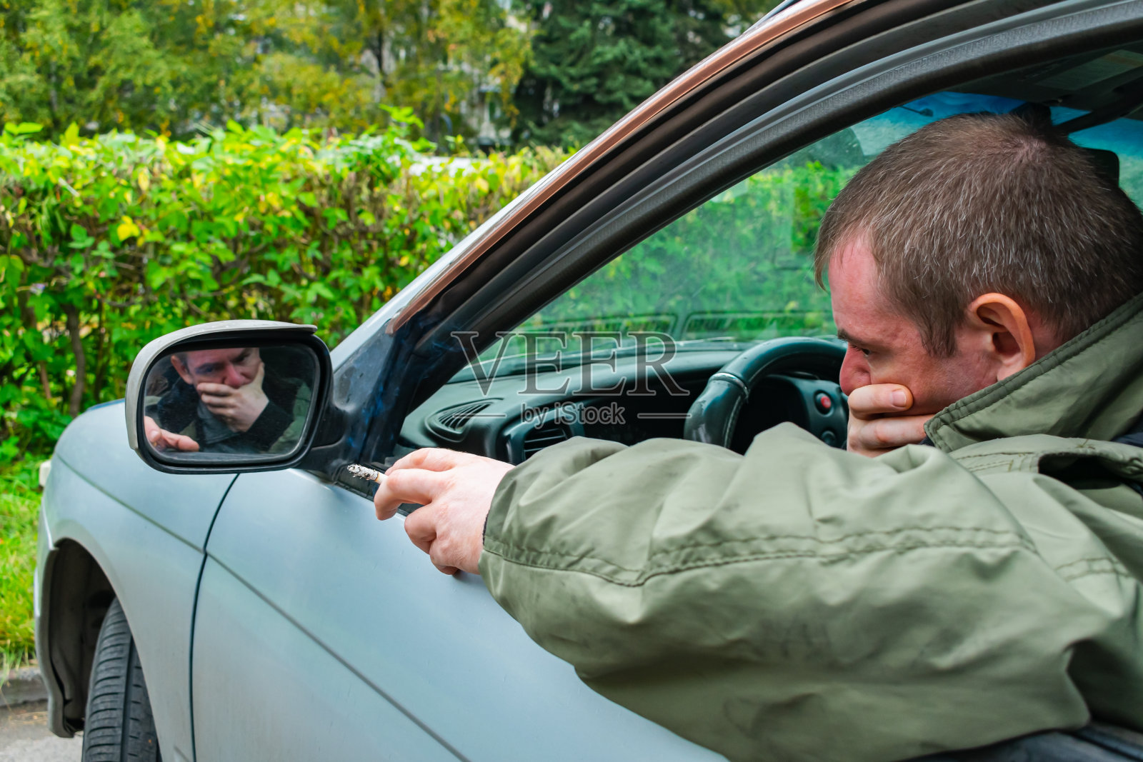 一个忧郁忧郁的男人坐在车里抽着烟照片摄影图片