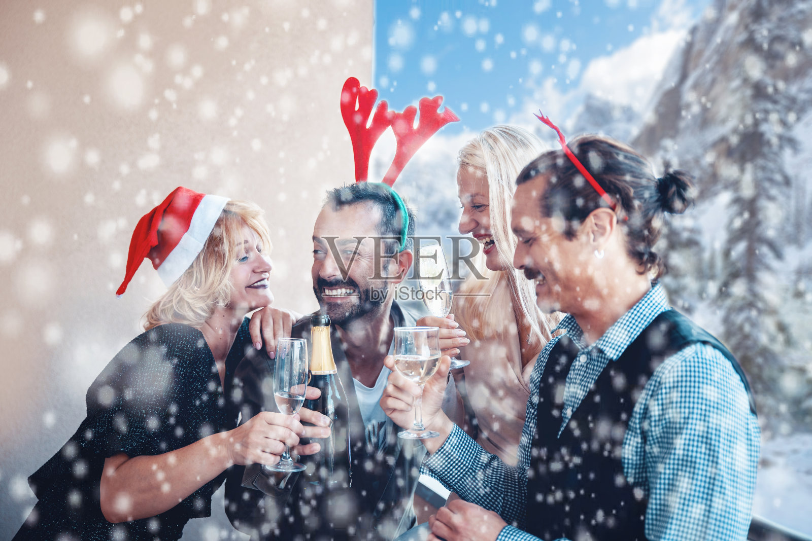 圣诞节下雪的时候，朋友们在阳台上喝香槟照片摄影图片