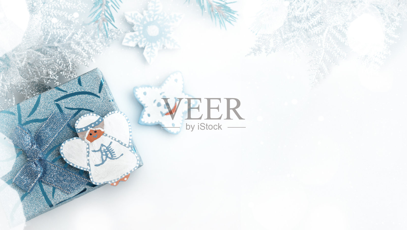 圣诞树下的礼品盒上装饰着蓝色的天使。圣诞节的横幅，复制的空间插画图片素材