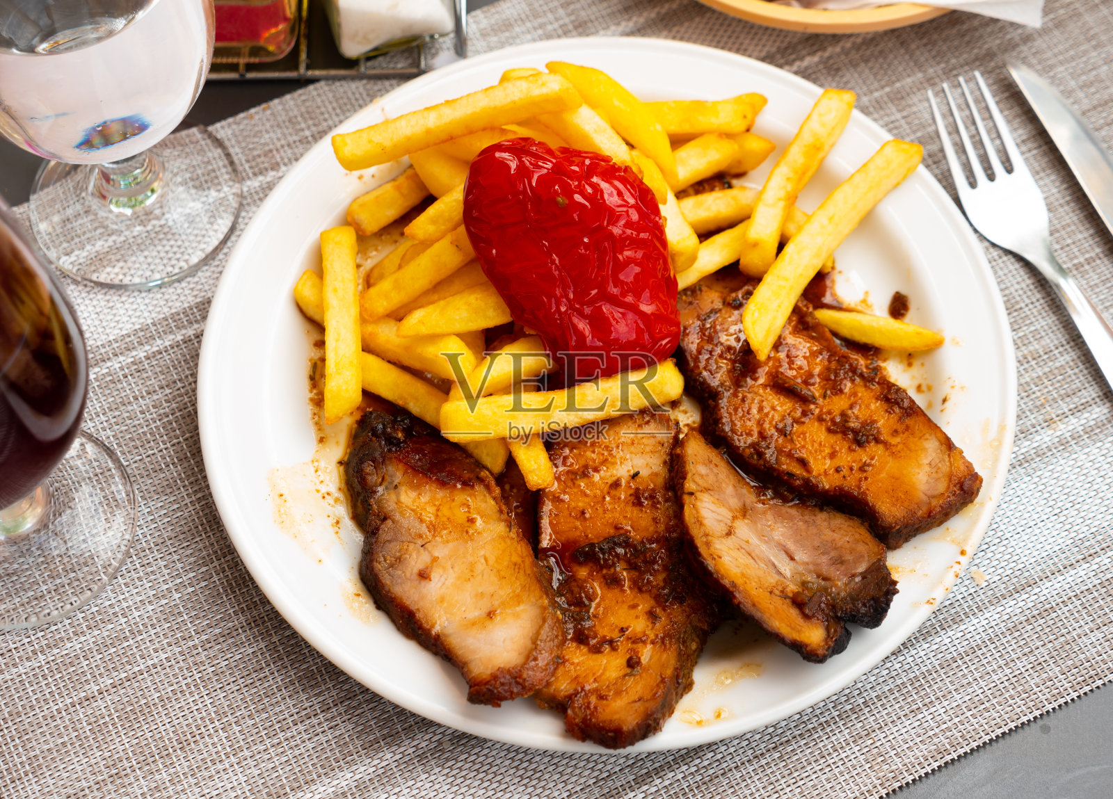 猪肉里脊配炸土豆和红辣椒照片摄影图片