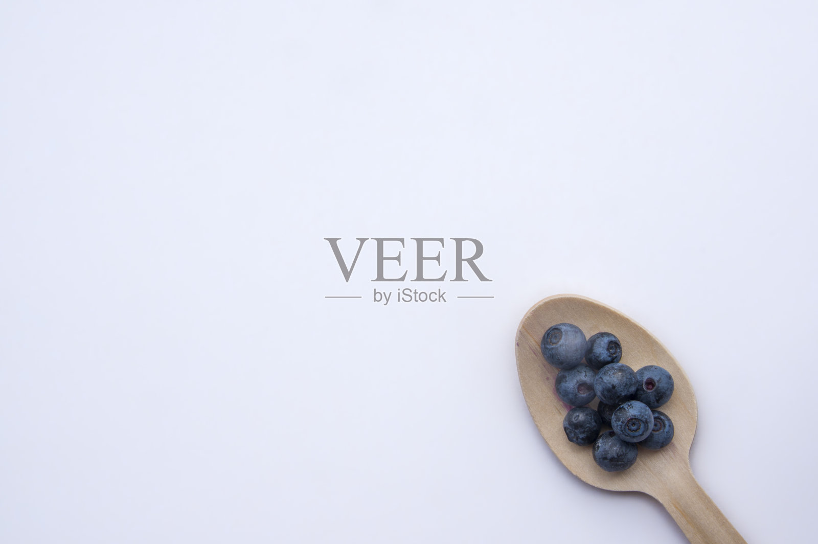 独立回收的勺子和多汁的新鲜蓝莓放在白色的桌子上照片摄影图片