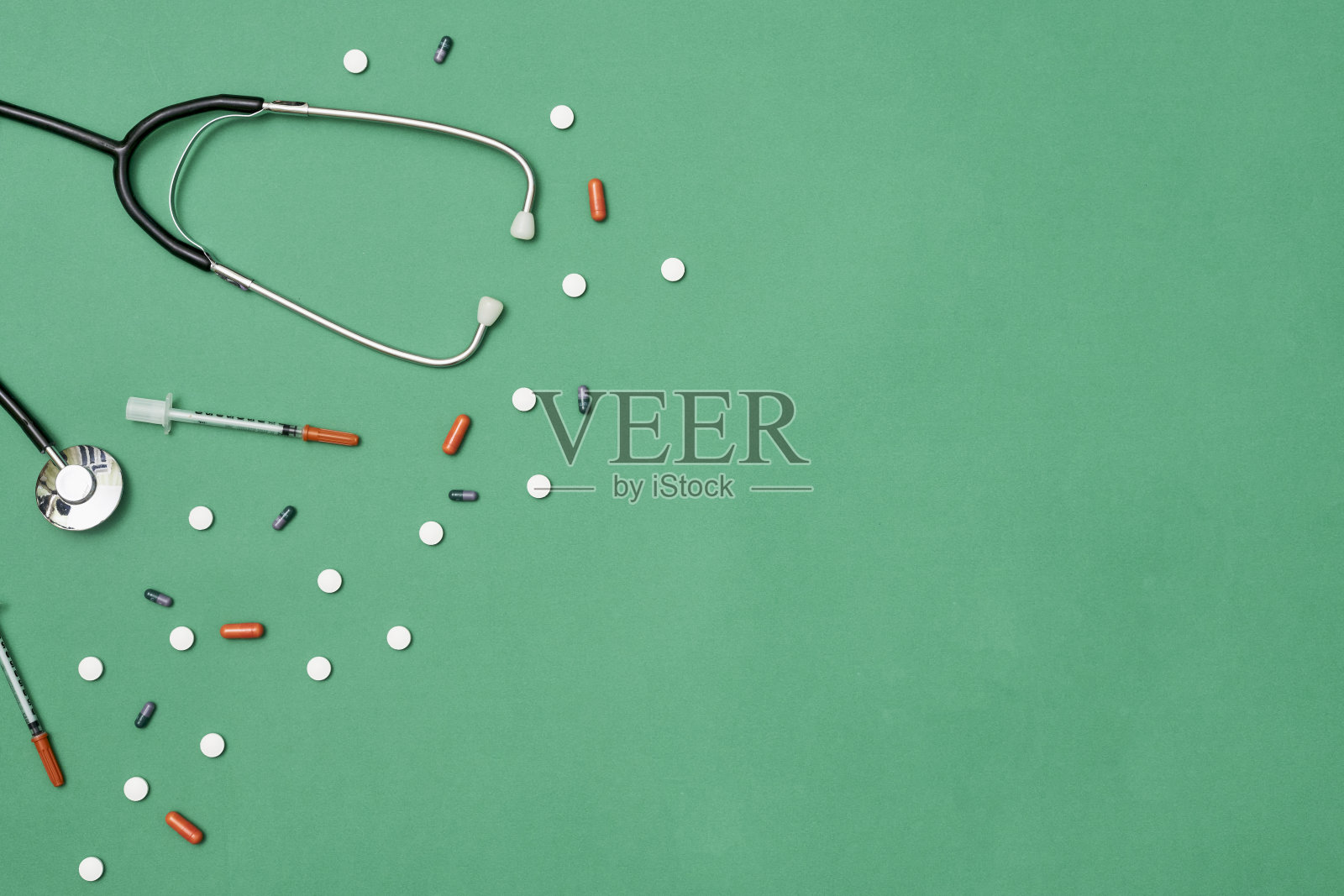 听诊器，药品和注射器在绿色上照片摄影图片