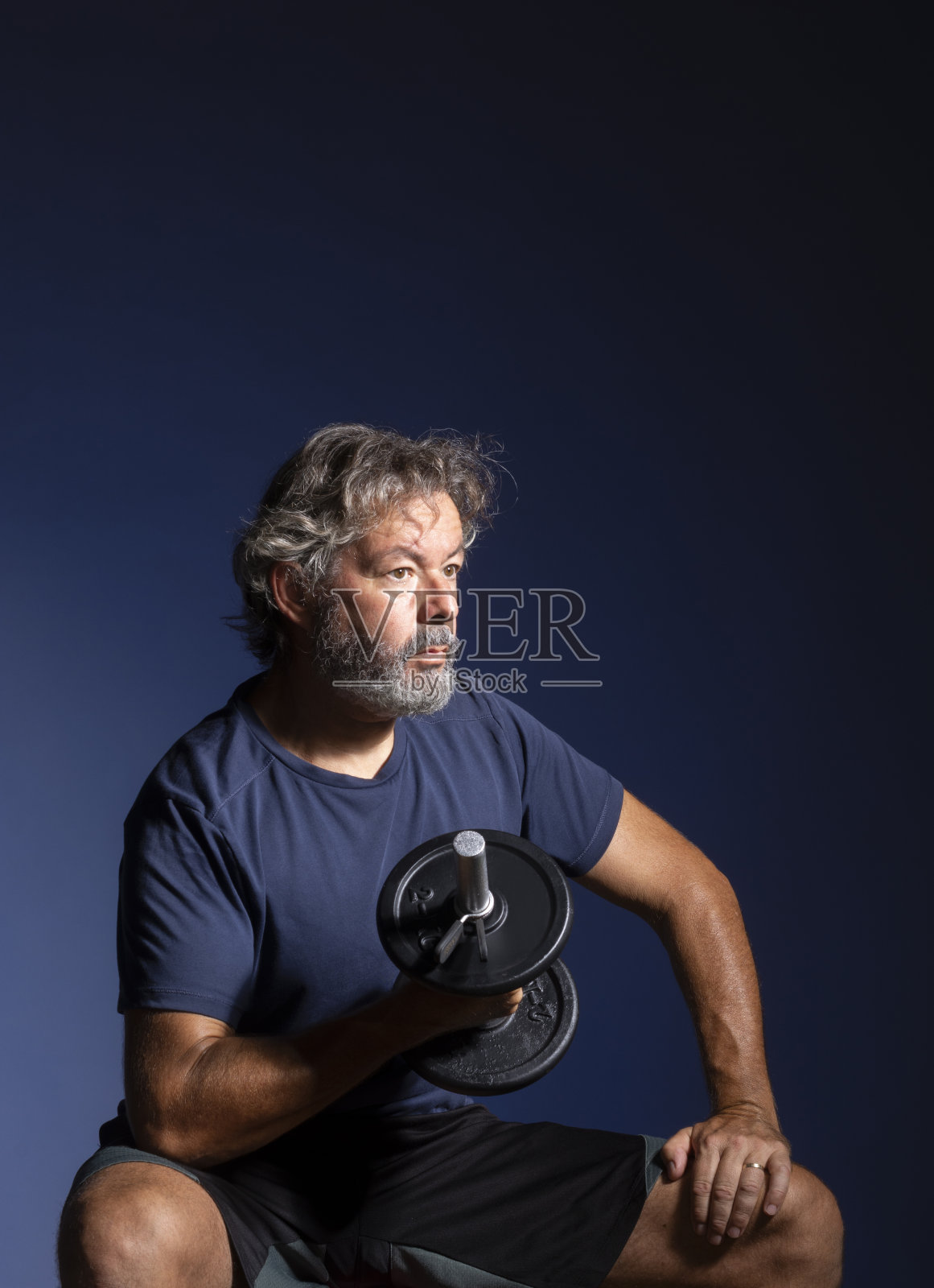 白发男子在做负重训练。高级健身。照片摄影图片