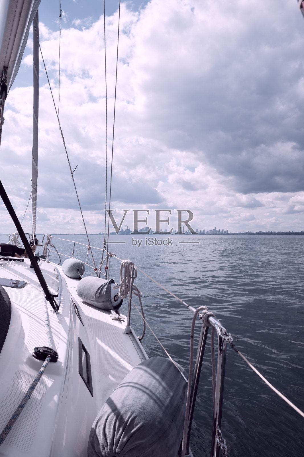 在安大略湖上航行的帆船，背景是多伦多市中心照片摄影图片