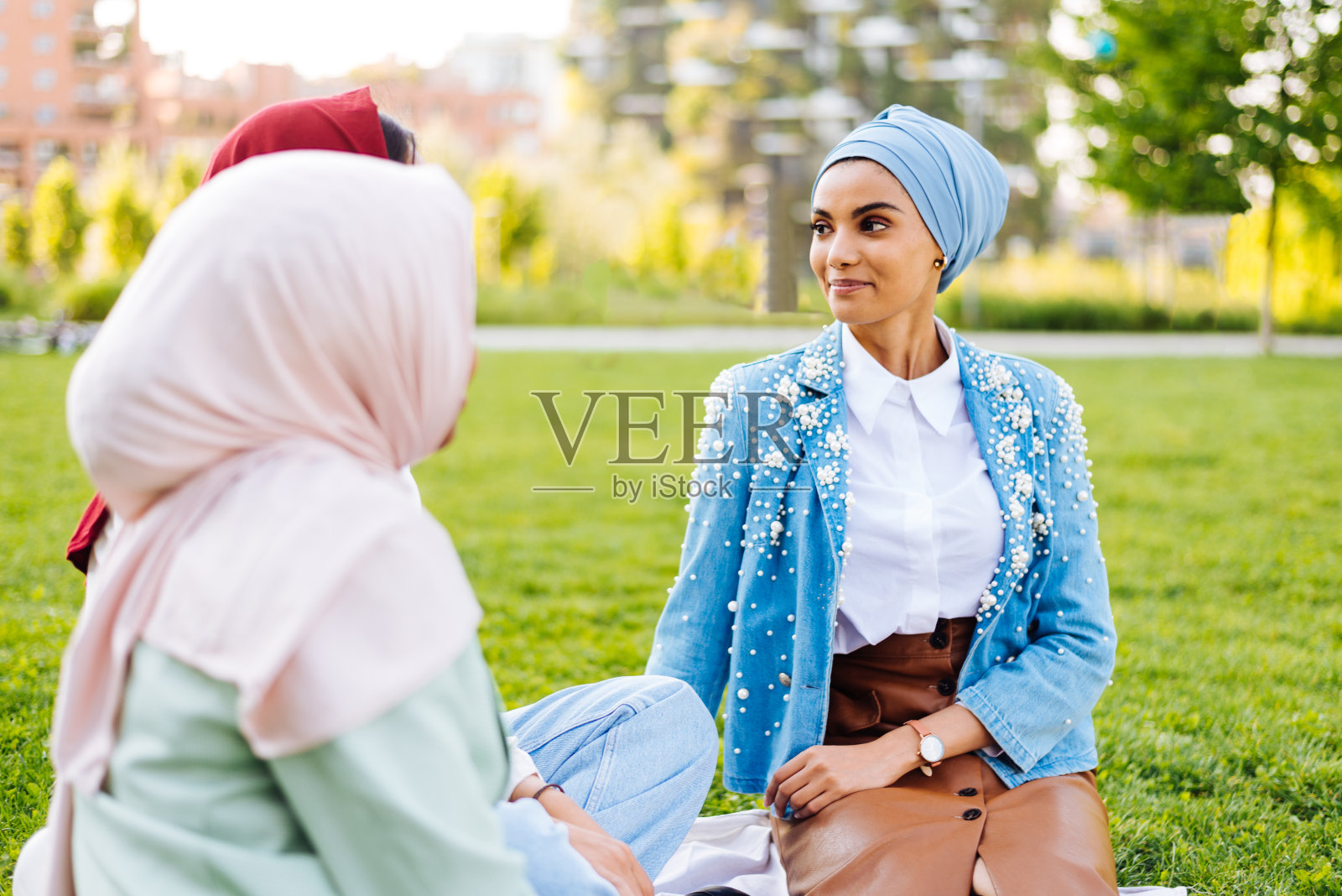 美丽的穆斯林女孩戴着头巾在户外聊天照片摄影图片
