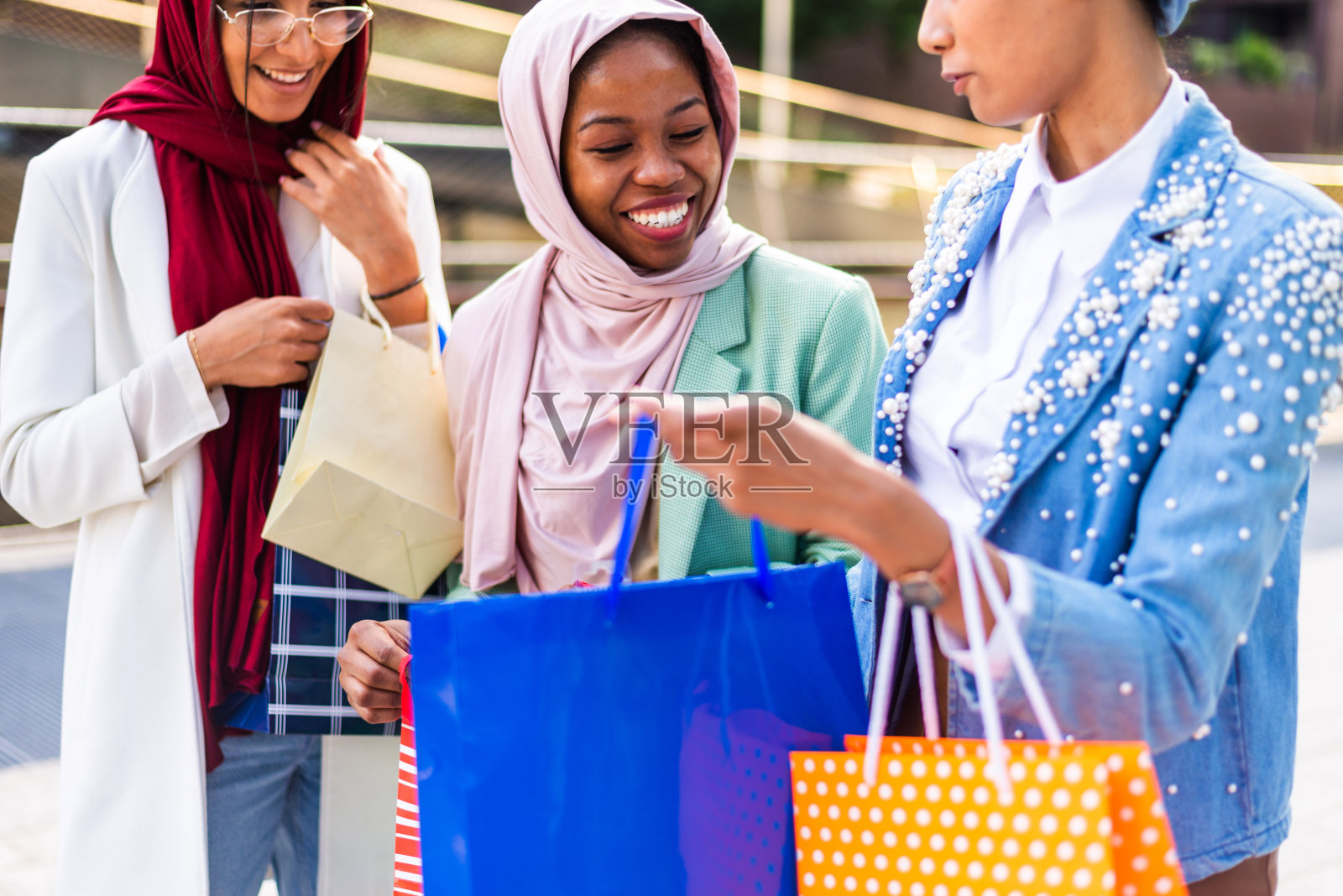 美丽的穆斯林女孩戴着头巾在户外聊天照片摄影图片