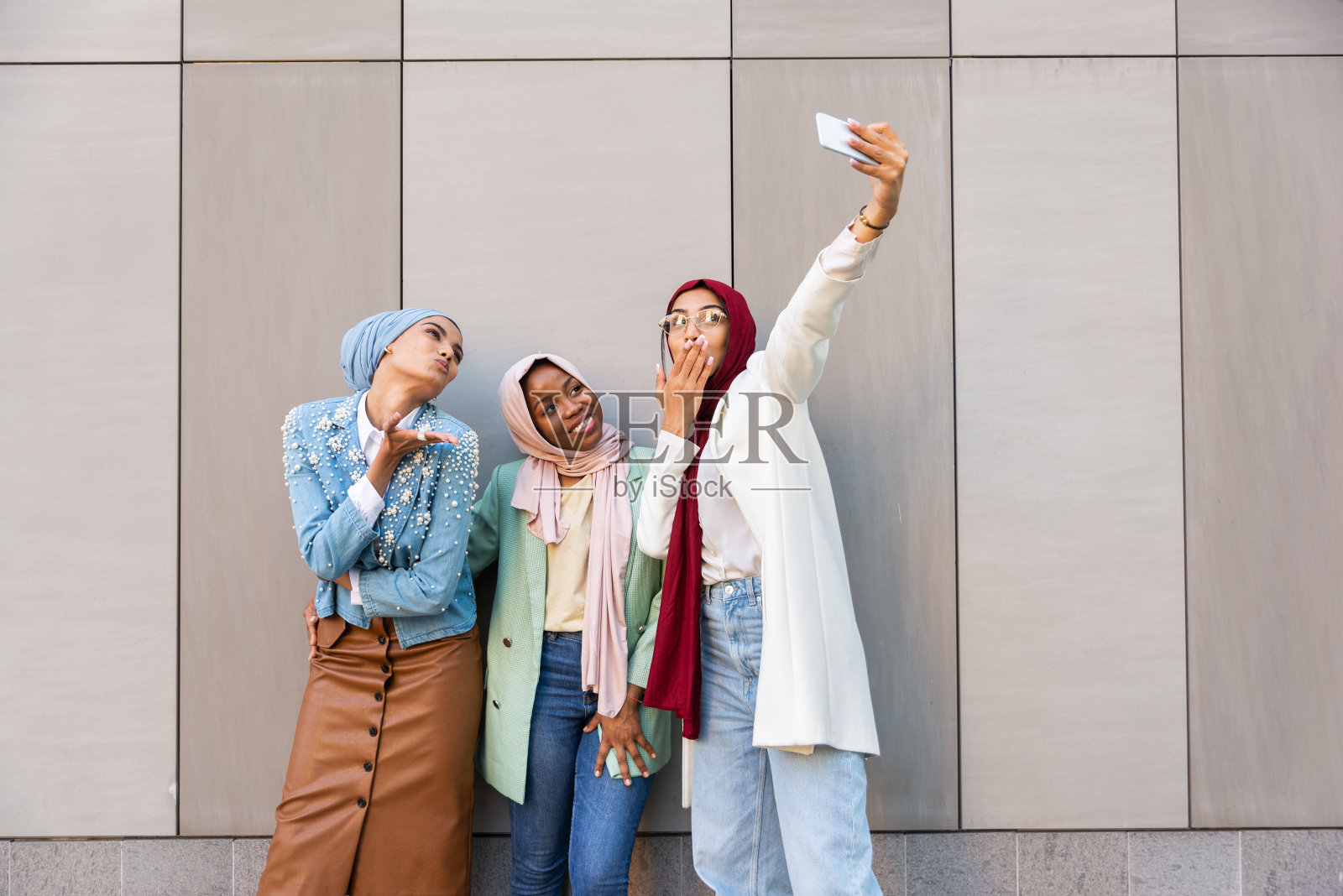 美丽的穆斯林女孩戴着头巾在户外聊天照片摄影图片