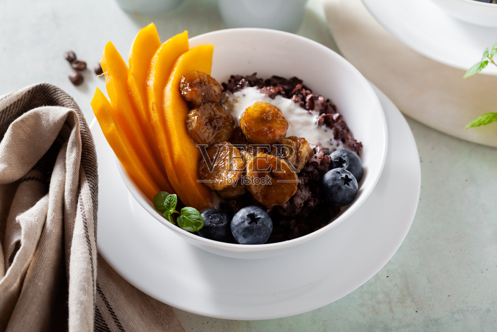 加勒比香甜早餐，黑米粥，椰奶，芒果，炸香蕉。健康的牙买加美食。和咖啡照片摄影图片