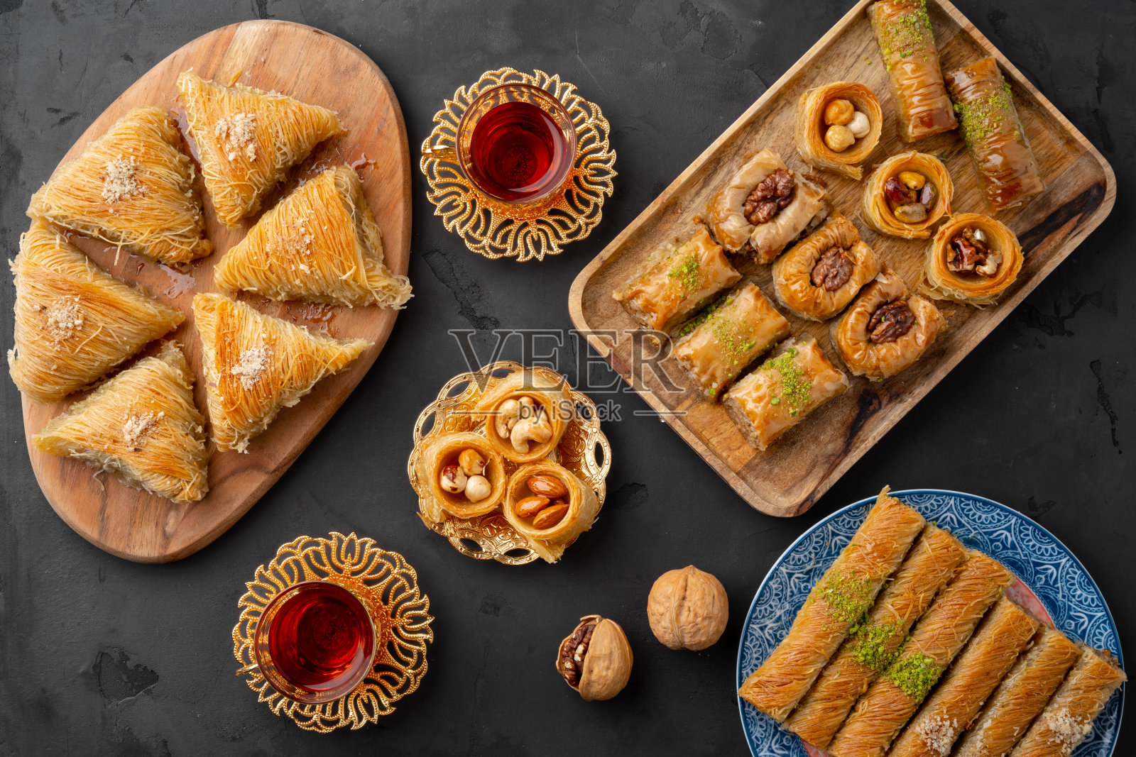 土耳其茶在传统的玻璃杯果仁饼在黑色的背景照片摄影图片