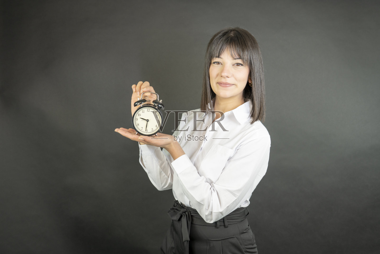 拿着闹钟的女商人。最后期限的问题，概念。照片摄影图片