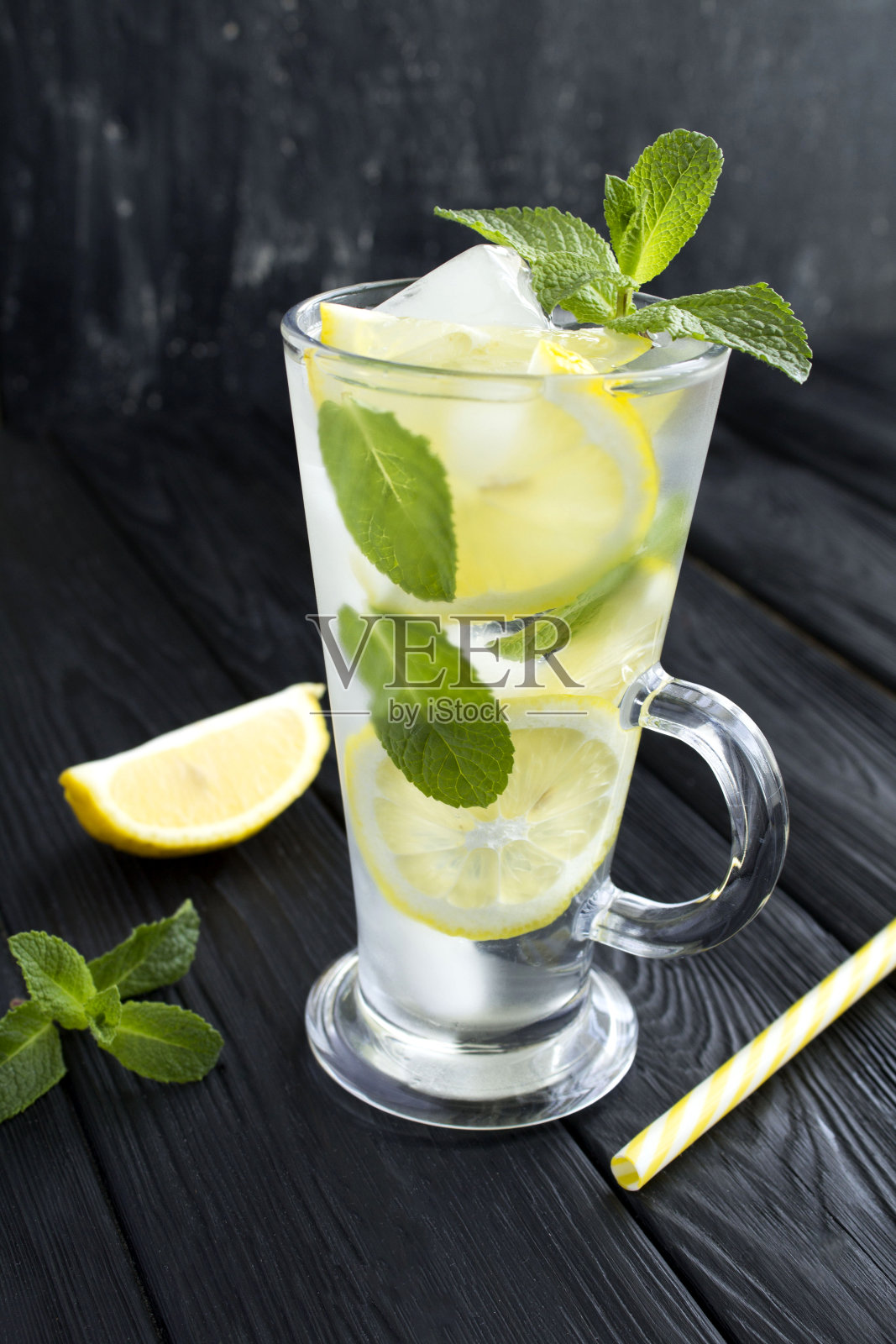 柠檬水或加入柠檬和薄荷的水在黑暗的背景上照片摄影图片