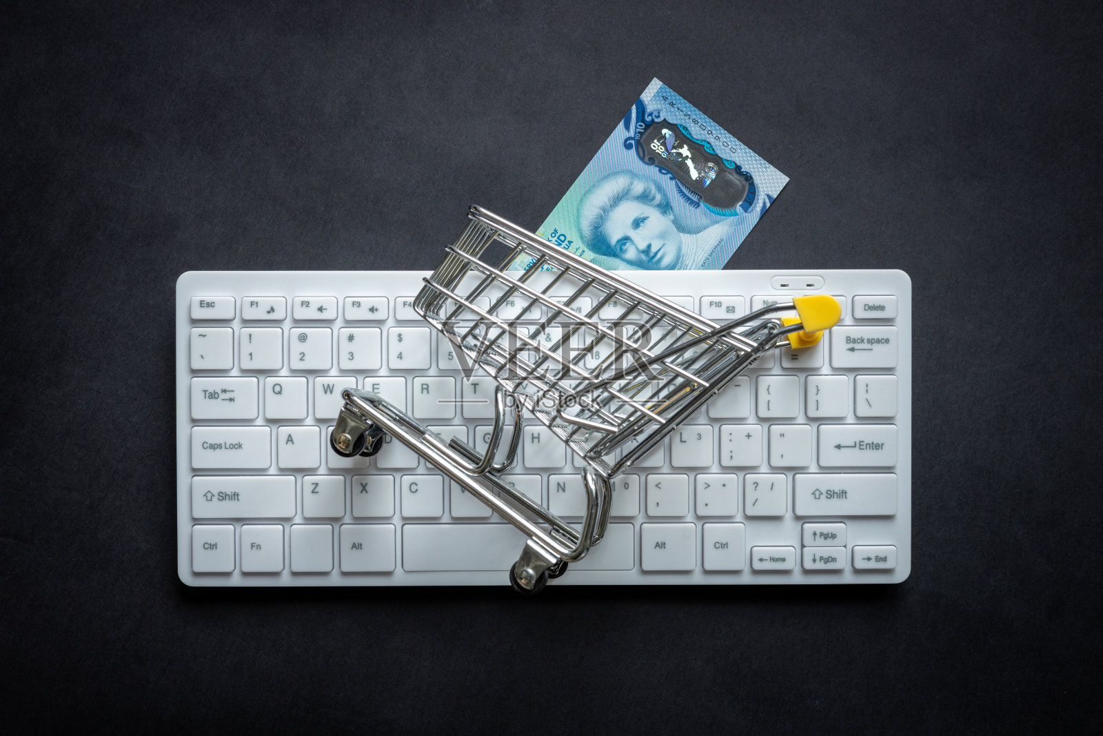 新西兰元，白色电脑键盘，迷你购物车，黑色背景，网上购物概念，低价照片摄影图片