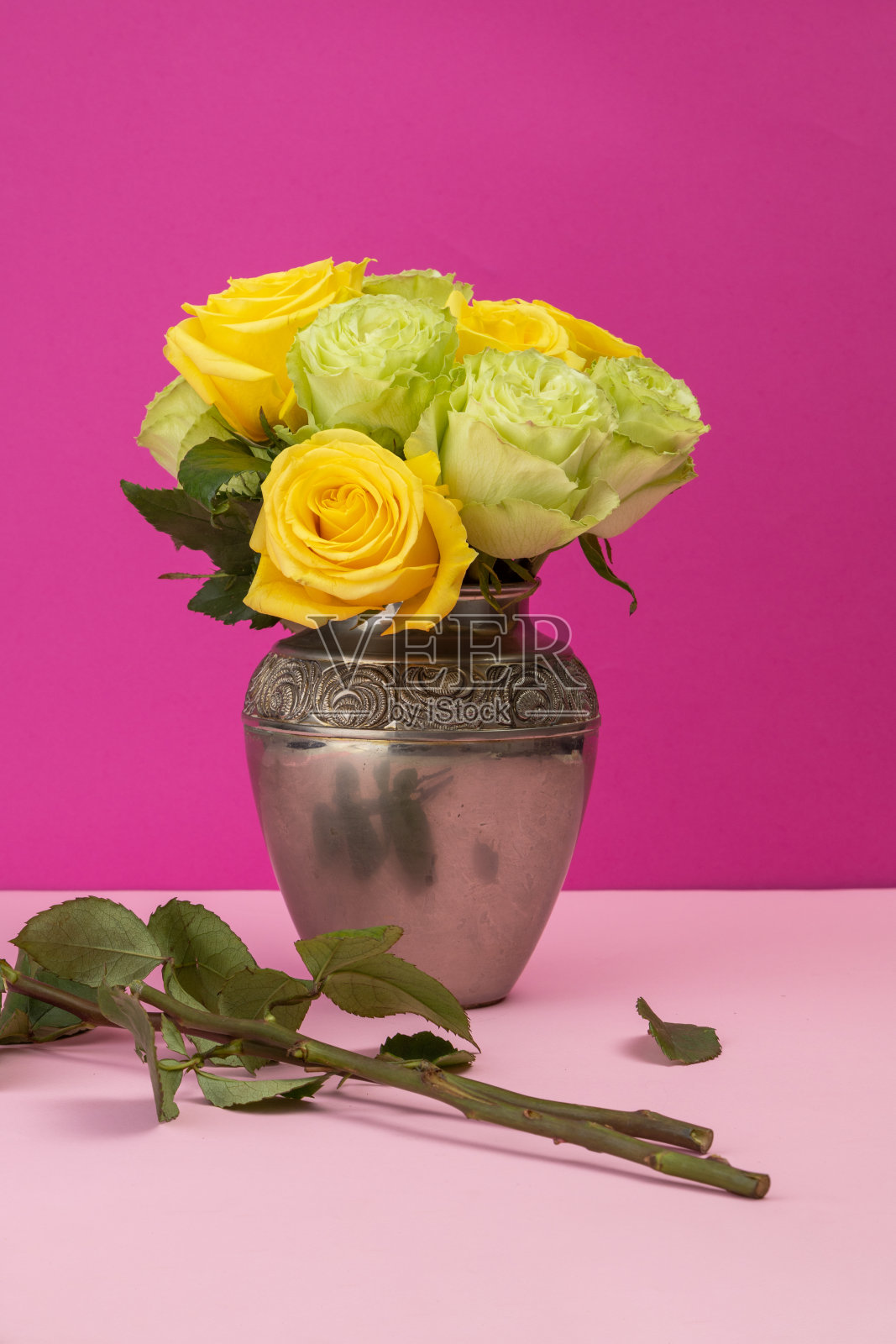 金属花瓶内的黄玫瑰插花，工作室内自然花卉的美丽装饰，自然和物体的细节照片摄影图片