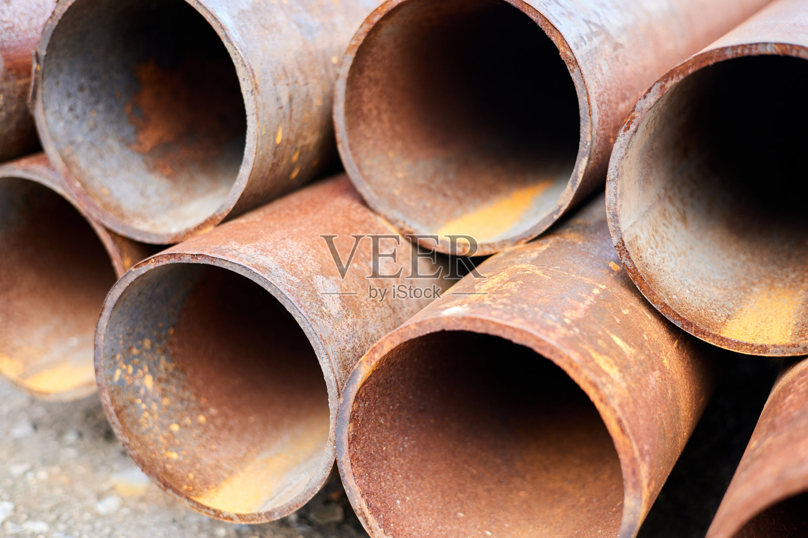 一堆生锈的金属管躺在地上。特写,有选择性的重点照片摄影图片