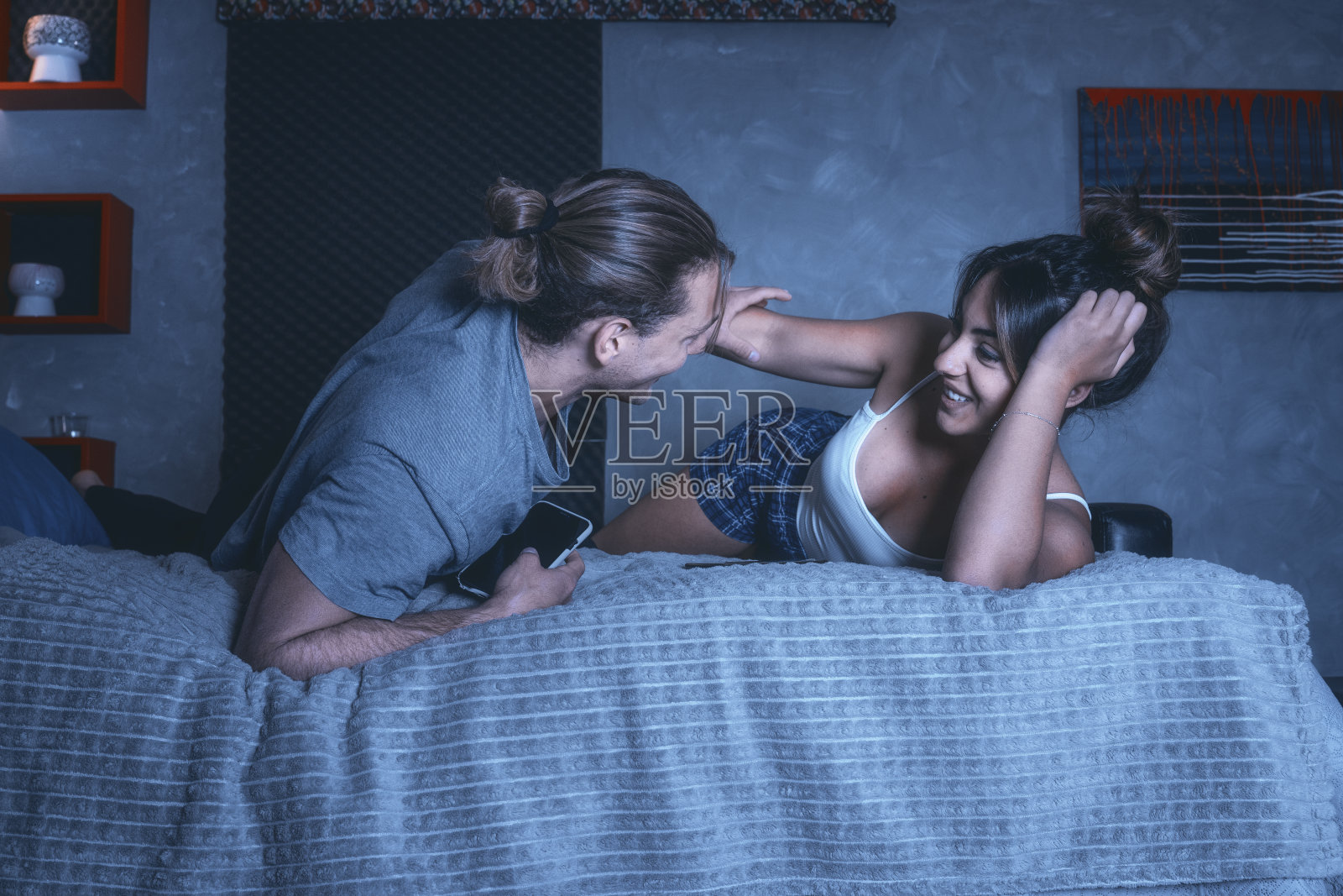 浪漫的白人情侣在卧室里分享手机信息照片摄影图片