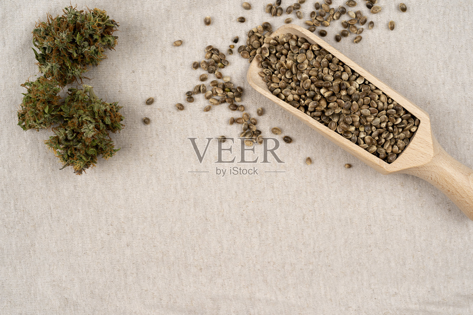 棕色木桌上用木勺盛着大麻种子。医用大麻的概念照片摄影图片