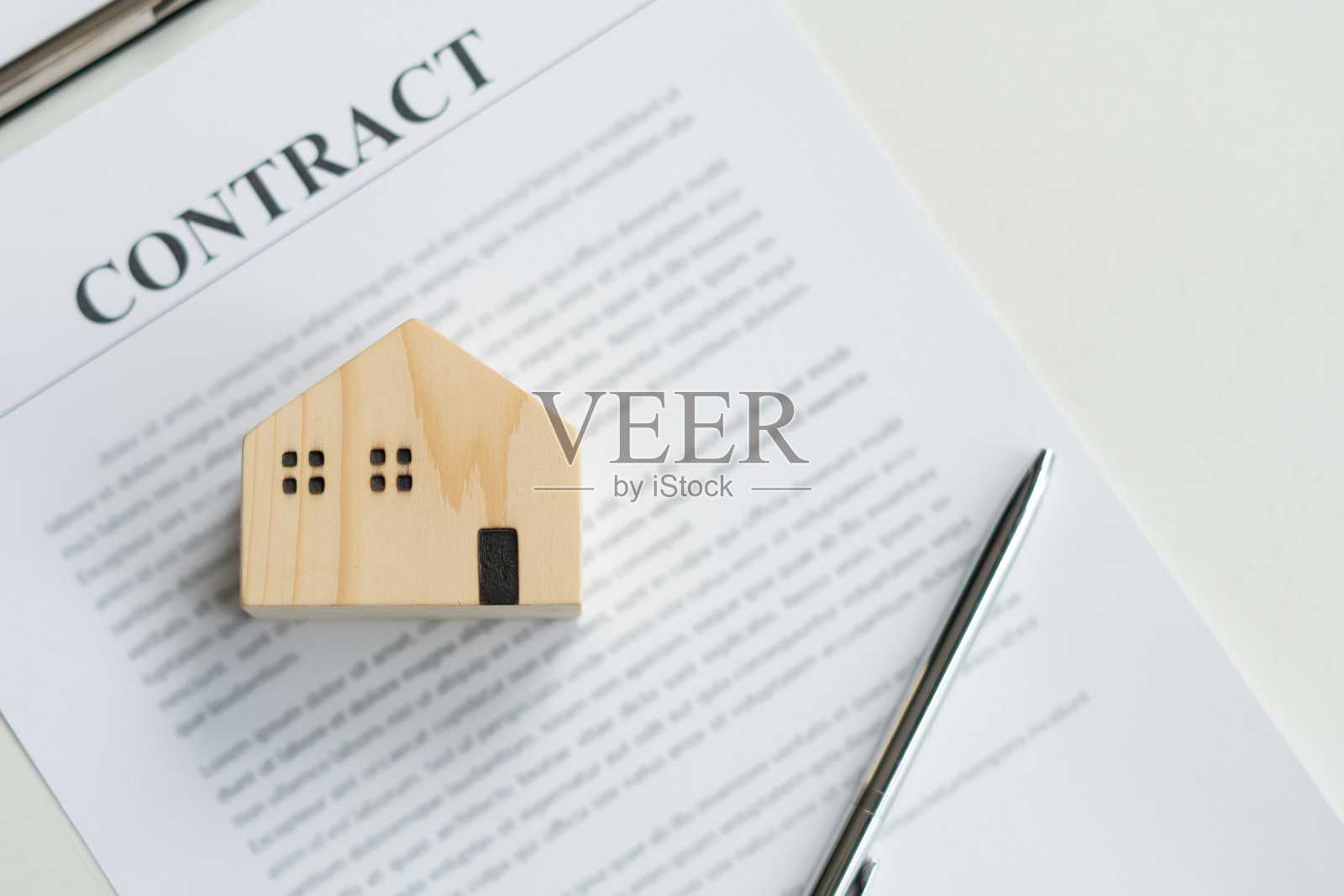 木房子和白色桌子上的租房合同。照片摄影图片