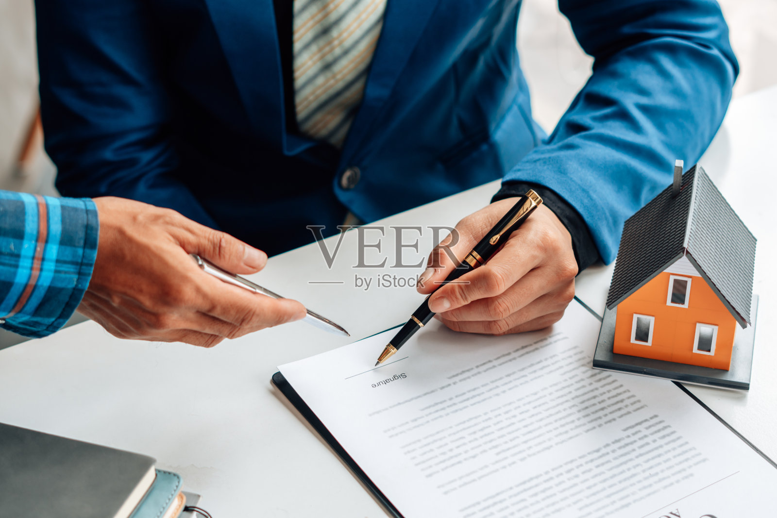 有兴趣购买房屋的客户要与房地产经纪人签署购房合同。按揭贷款批准，住房贷款和保险概念。照片摄影图片