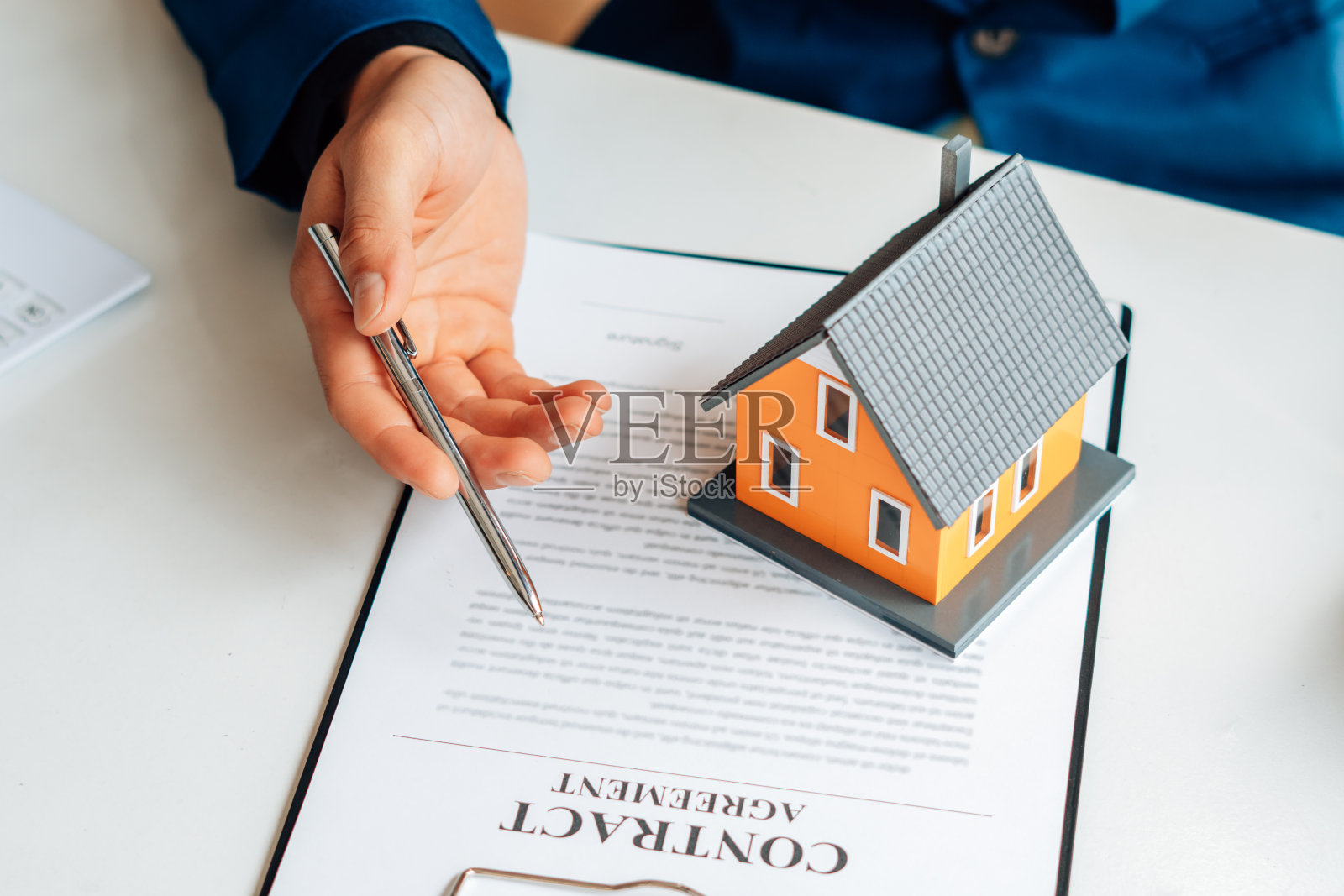 在办公室内签署相关文件后，买家和房地产中介就可以手牵手买卖租赁或购买房屋达成协议。照片摄影图片