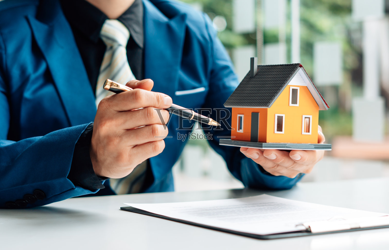 房地产经纪人正在向前来接洽看房子设计和购买协议的客户解释房子的风格。照片摄影图片