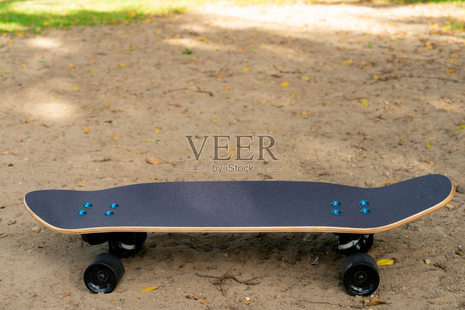 在公园里的沙滩上有一种黑色的冲浪滑板，它有黑色的滑板顶和黑色的轮子。照片摄影图片
