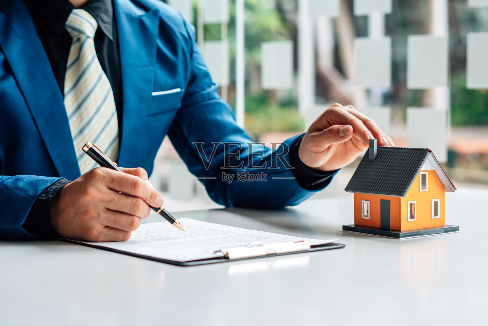 房地产经纪人正在向前来接洽看房子设计和购买协议的客户解释房子的风格。照片摄影图片