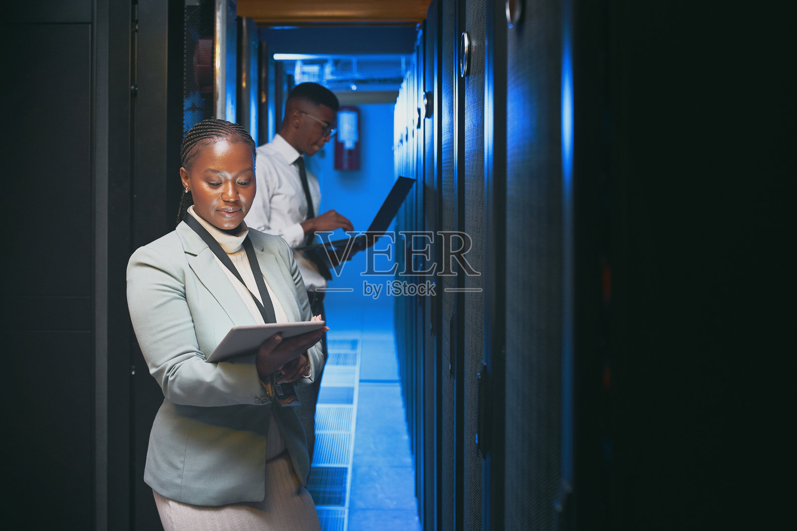 两个年轻的IT专家站在服务器室一起使用技术的镜头照片摄影图片