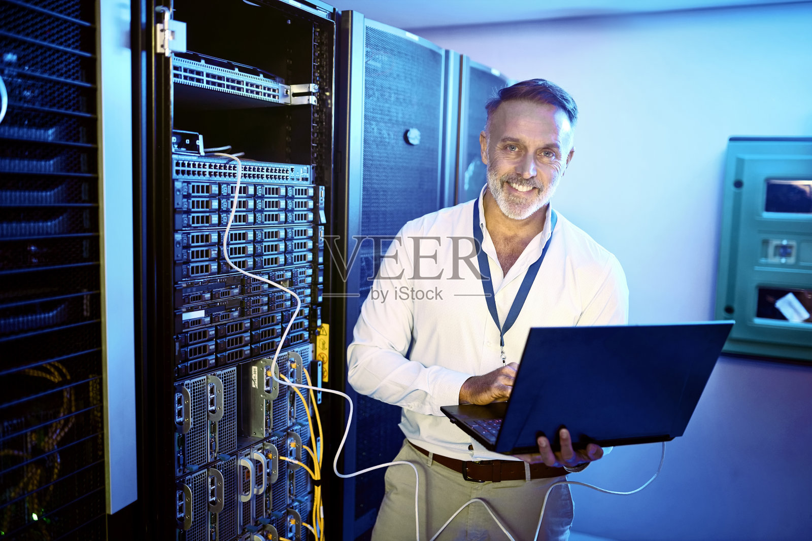 一个成熟的男人在服务器室工作时使用笔记本电脑照片摄影图片