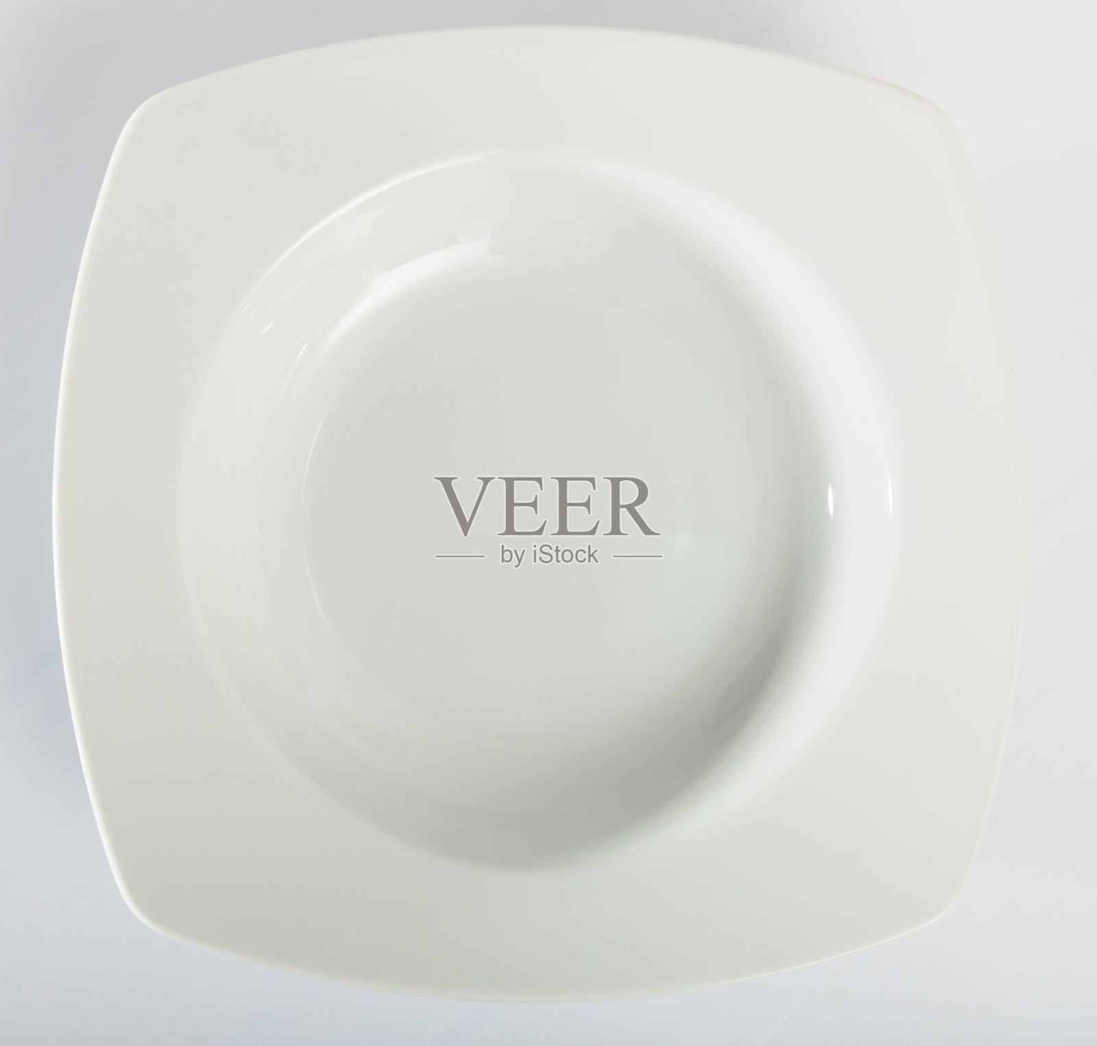 白色的桌子上放着白色的方形盘子照片摄影图片