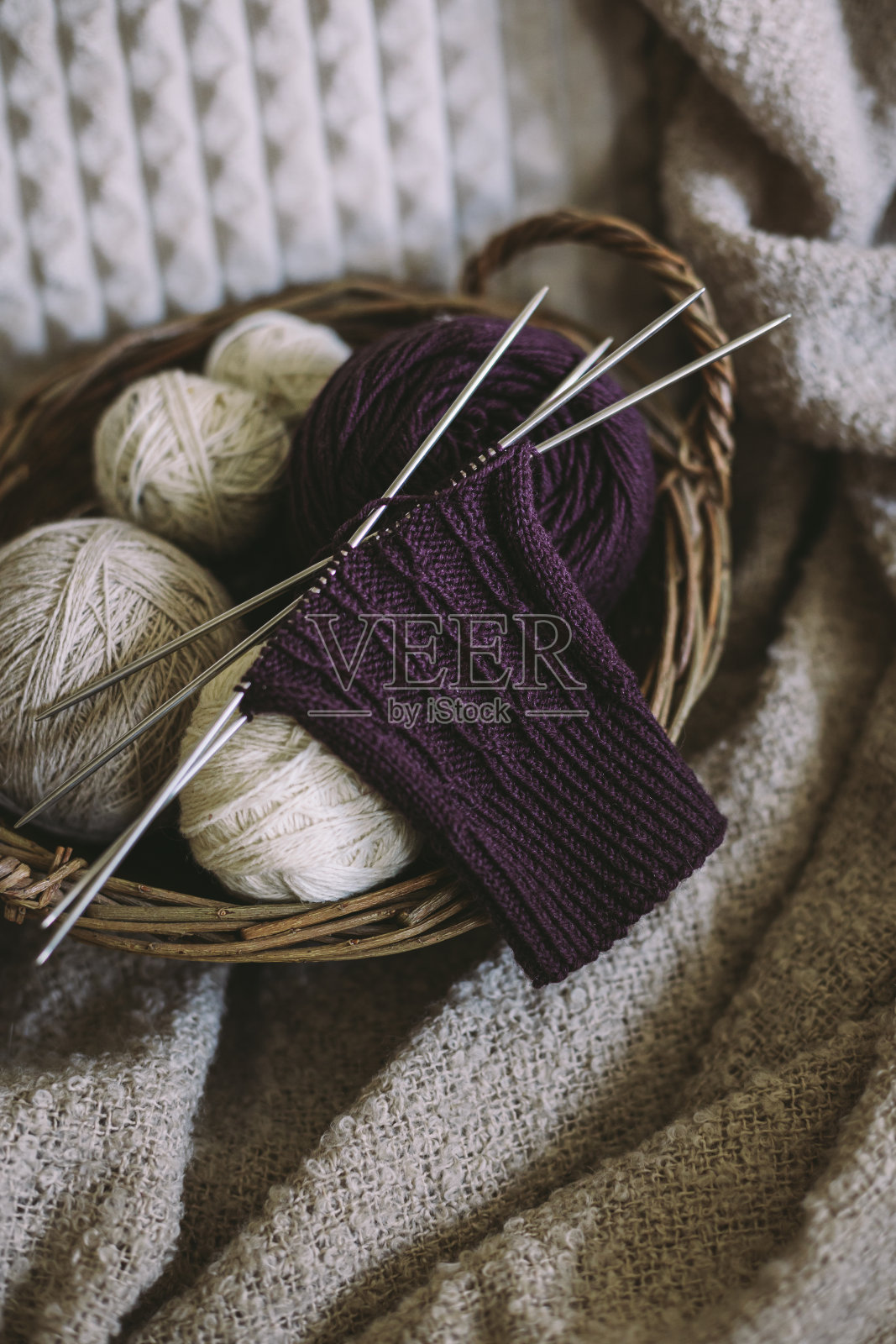 在篮子里用针和纱线球手工编织袜子。概念手工和hygge慢生活。照片摄影图片