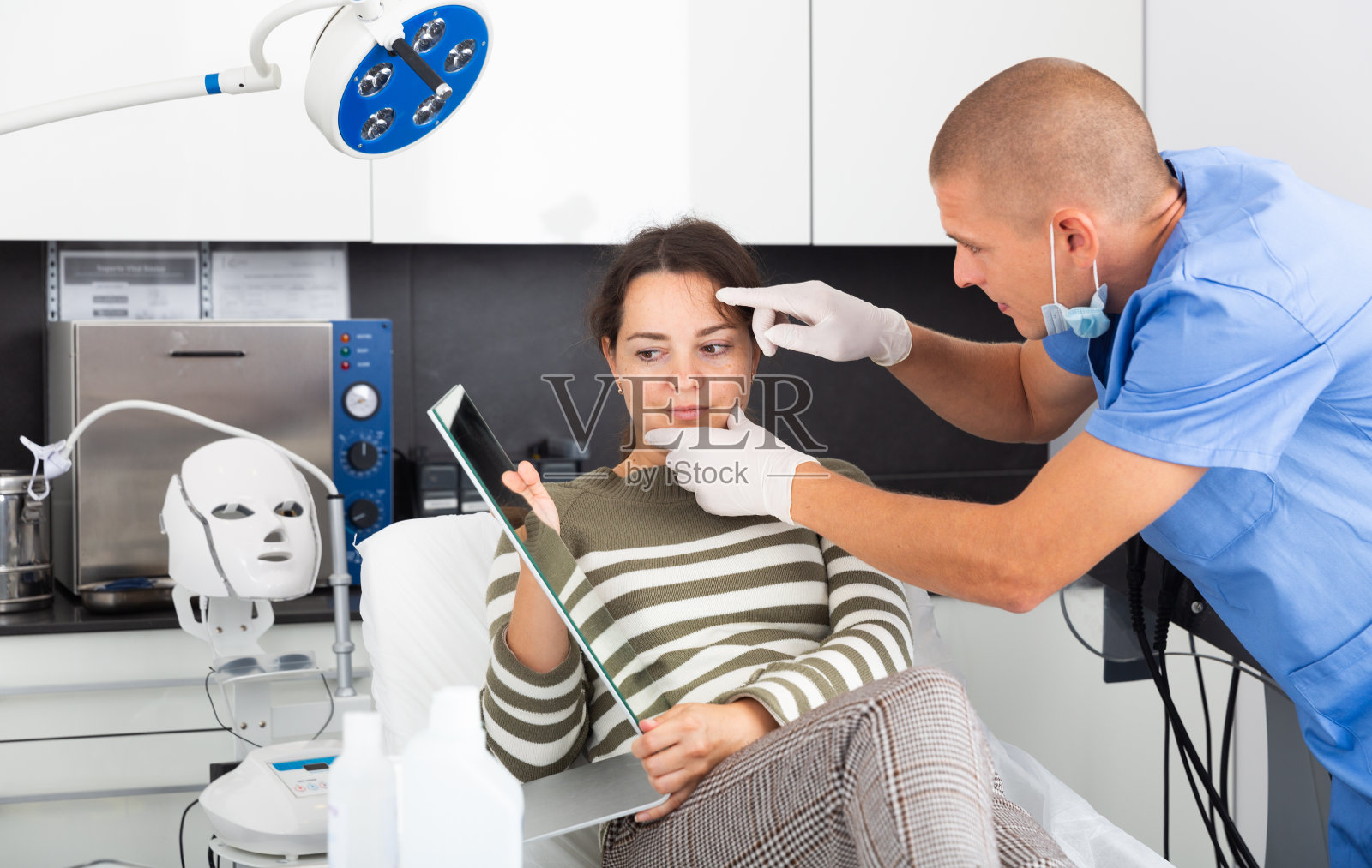 美容师检查女性面部皮肤手术后照片摄影图片