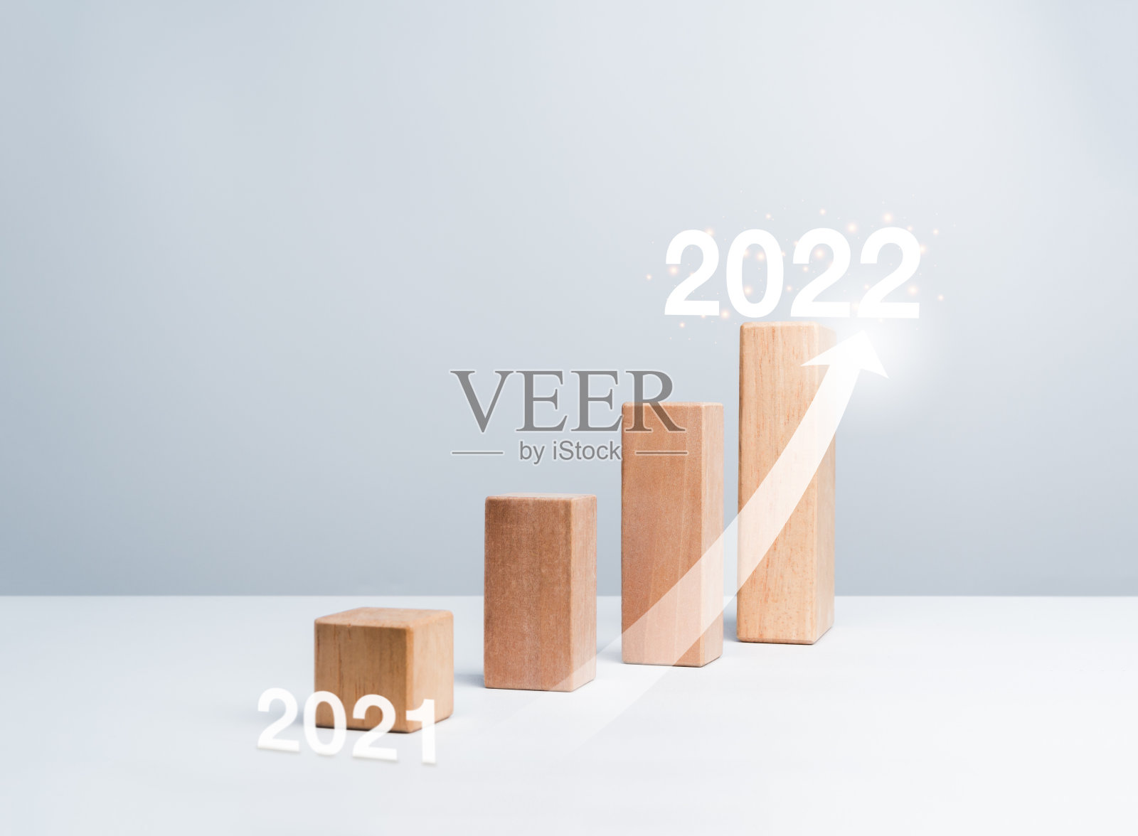 从2021年到2022年，在木块图的步骤上闪亮的上升箭头。照片摄影图片