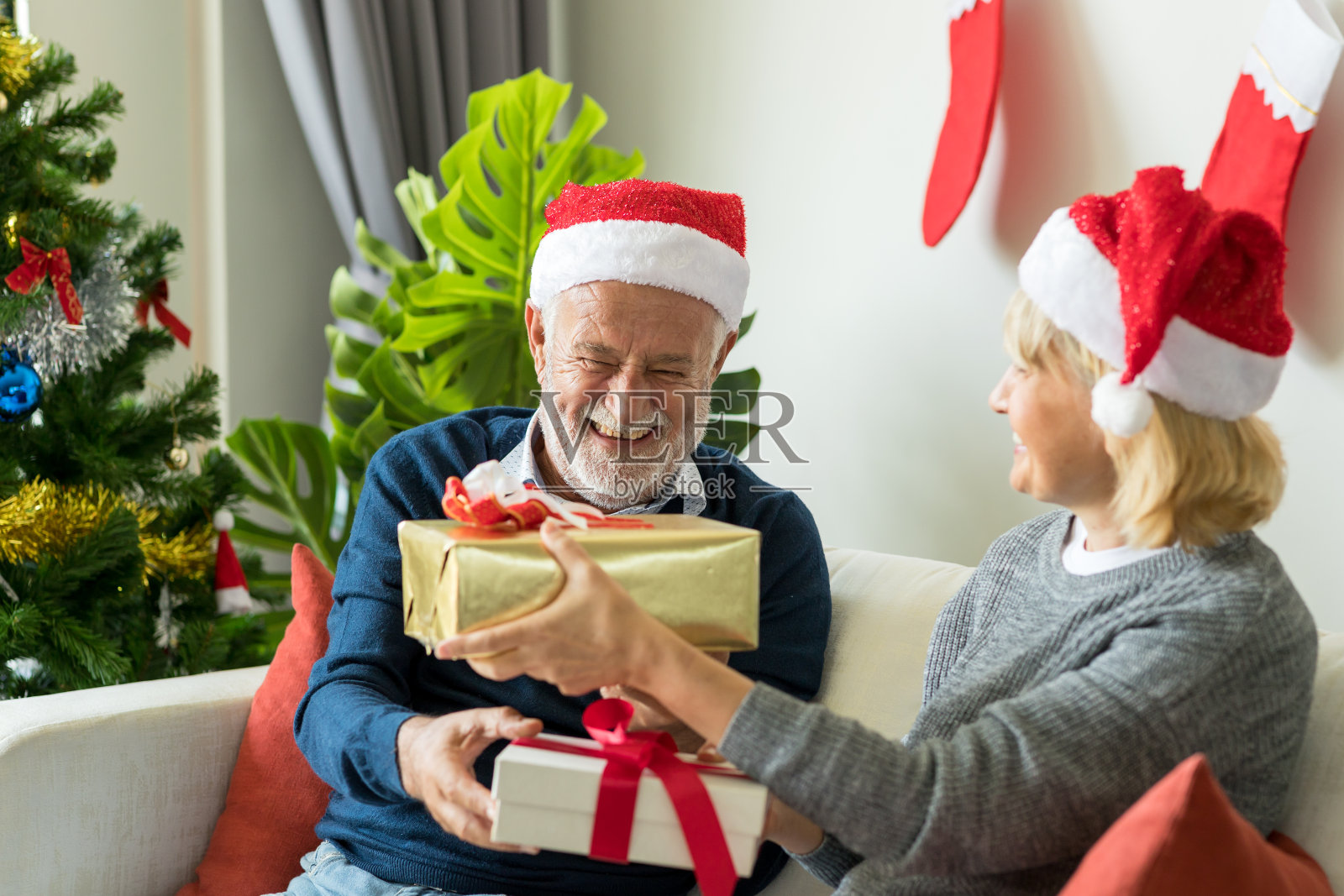 快乐的老年夫妇在圣诞节交换圣诞礼物照片摄影图片