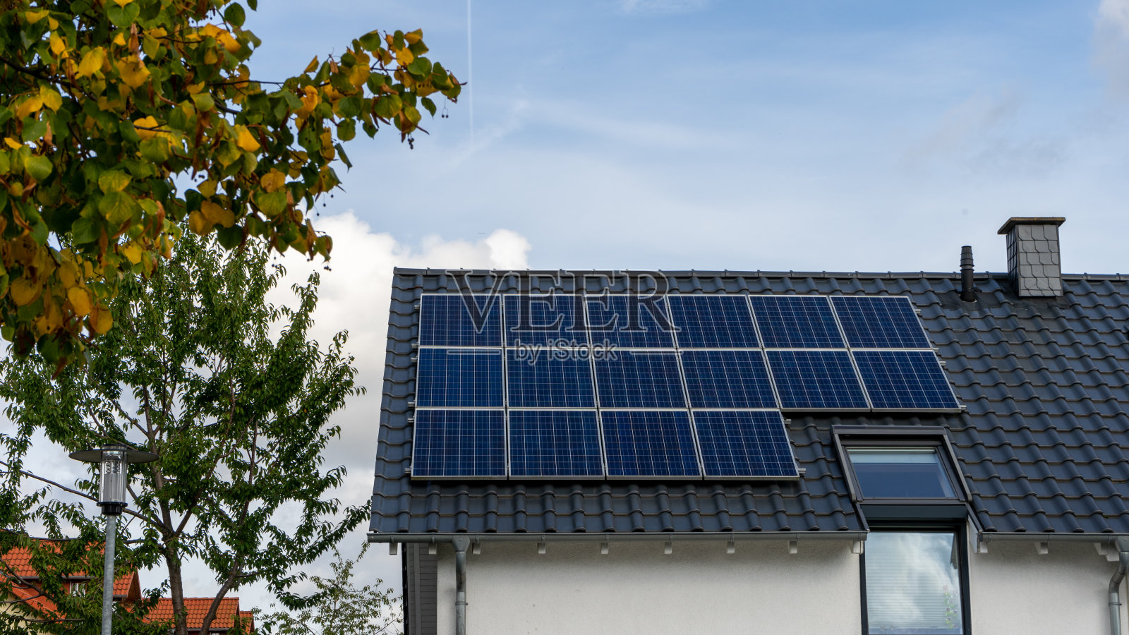 一个家庭的屋顶上安装了新的太阳能电池板。照片摄影图片