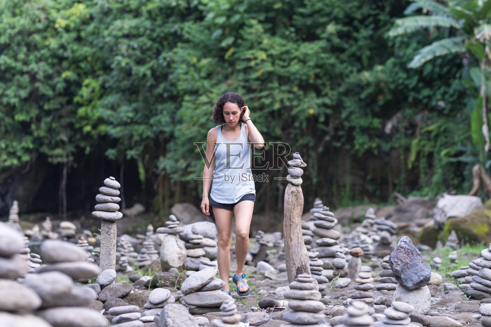 亚洲的混血妇女走过成堆的石冢照片摄影图片