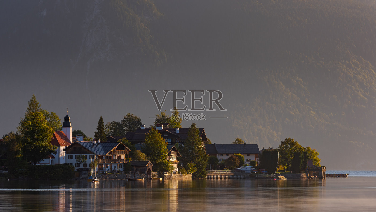 清晨时分，阿尔卑斯山湖瓦chensee上的瓦chensee村庄，背景是群山照片摄影图片