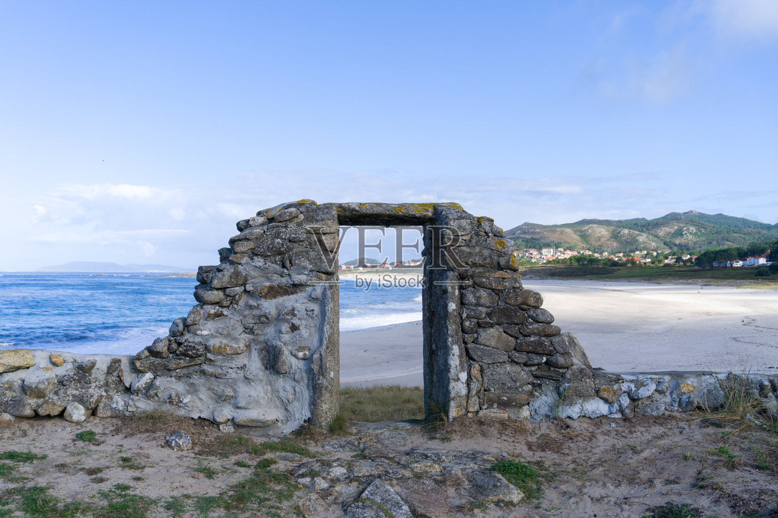 一个石头建筑废墟的门，Lariño海滩的背景。Ancoradoiro muro,加利西亚。照片摄影图片