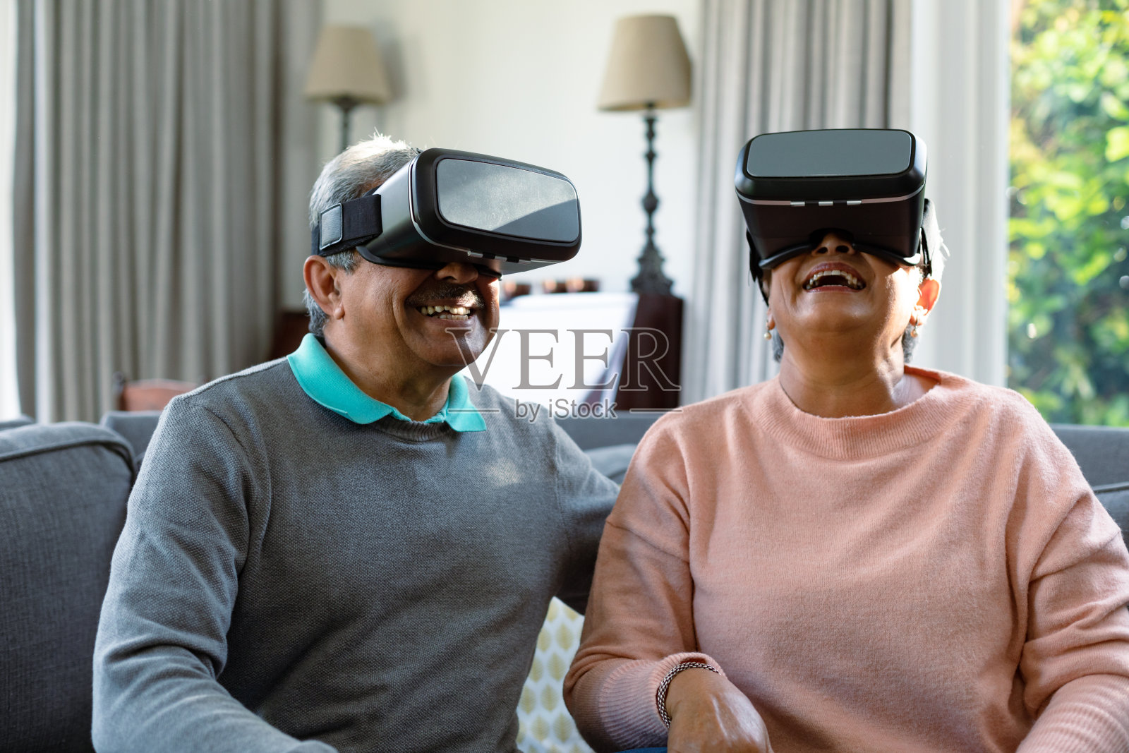 两对快乐的多样化老年夫妇戴着虚拟现实头盔，享受乐趣照片摄影图片