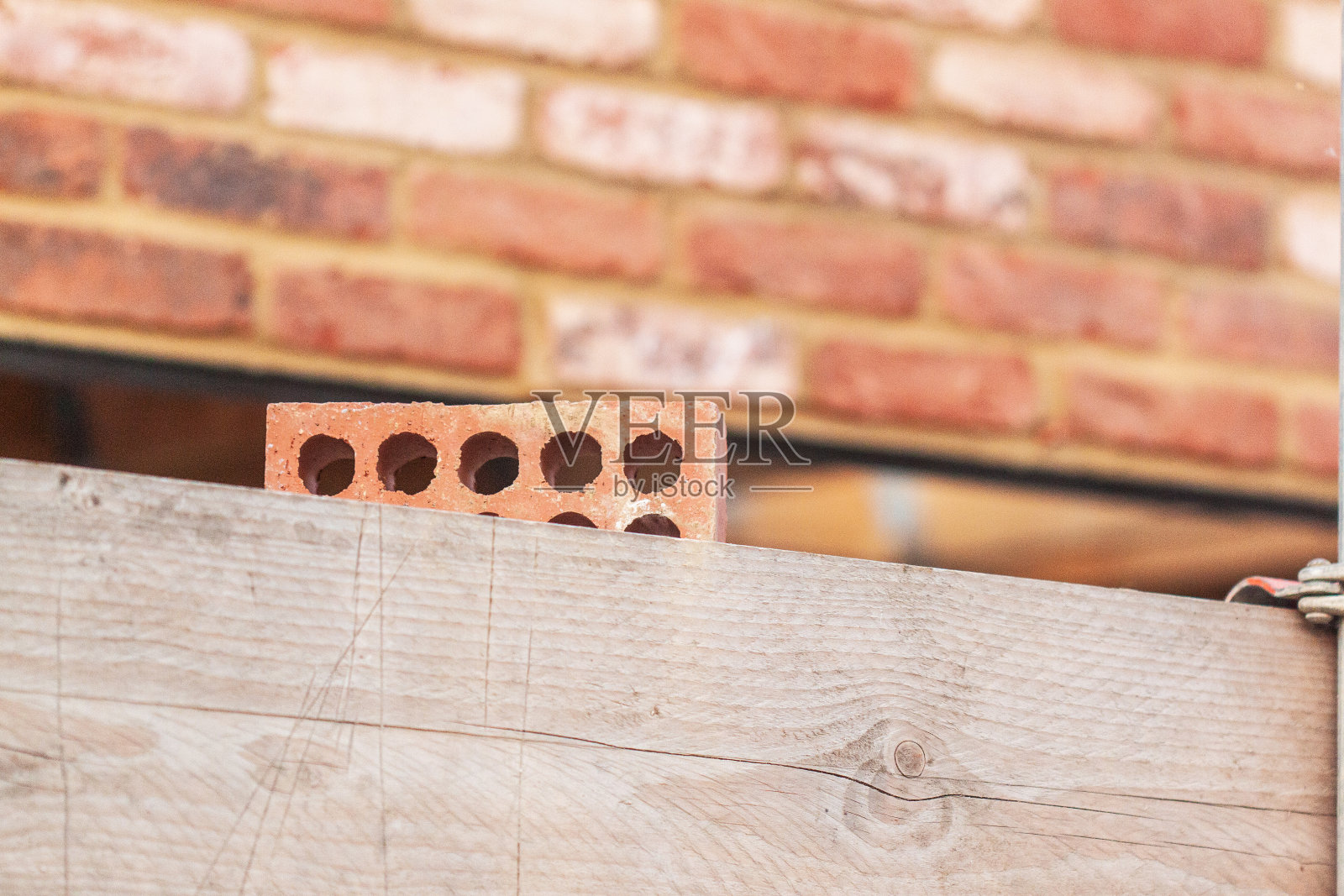 砌块砖在砌块砖前面脚手架板上的随意的建筑砖照片摄影图片