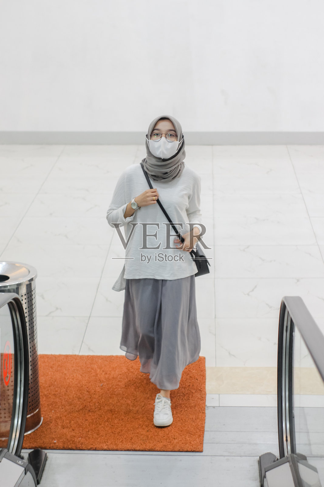 亚洲女人在电梯上戴口罩照片摄影图片