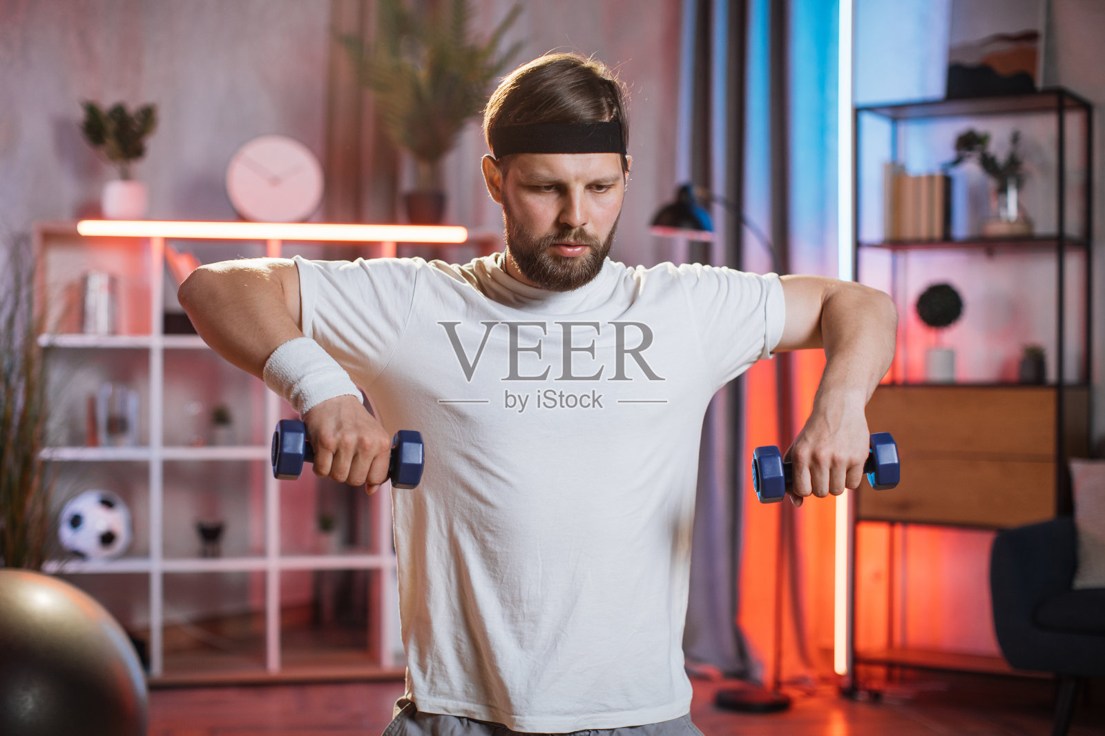 全神贯注的男子用哑铃练习手臂照片摄影图片