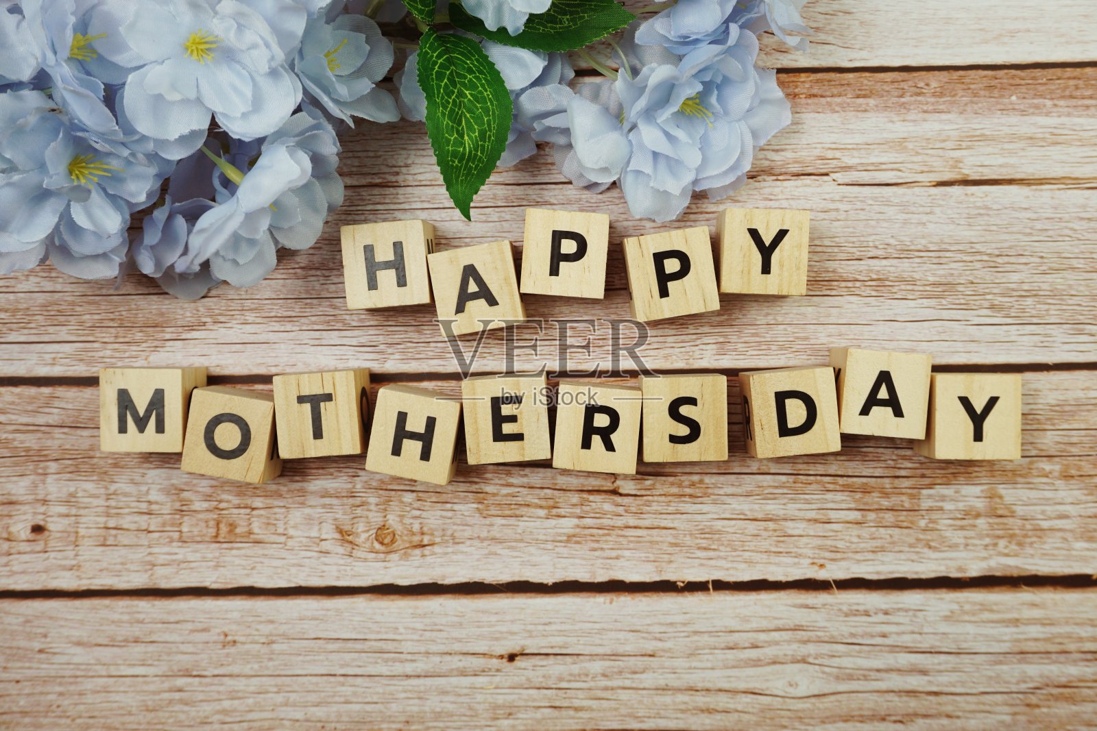 木制背景上装饰有花朵的“母亲节快乐”字母信照片摄影图片