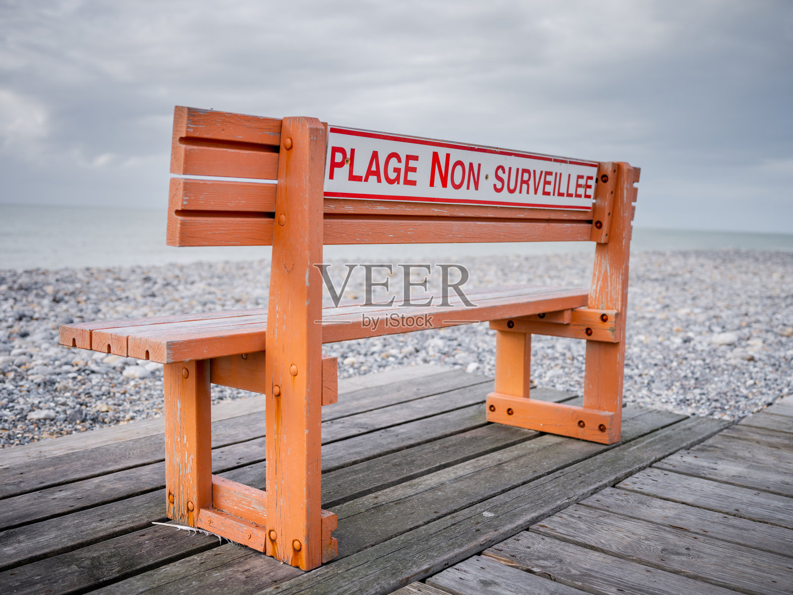 在无人看管的海滩上的公共长椅照片摄影图片