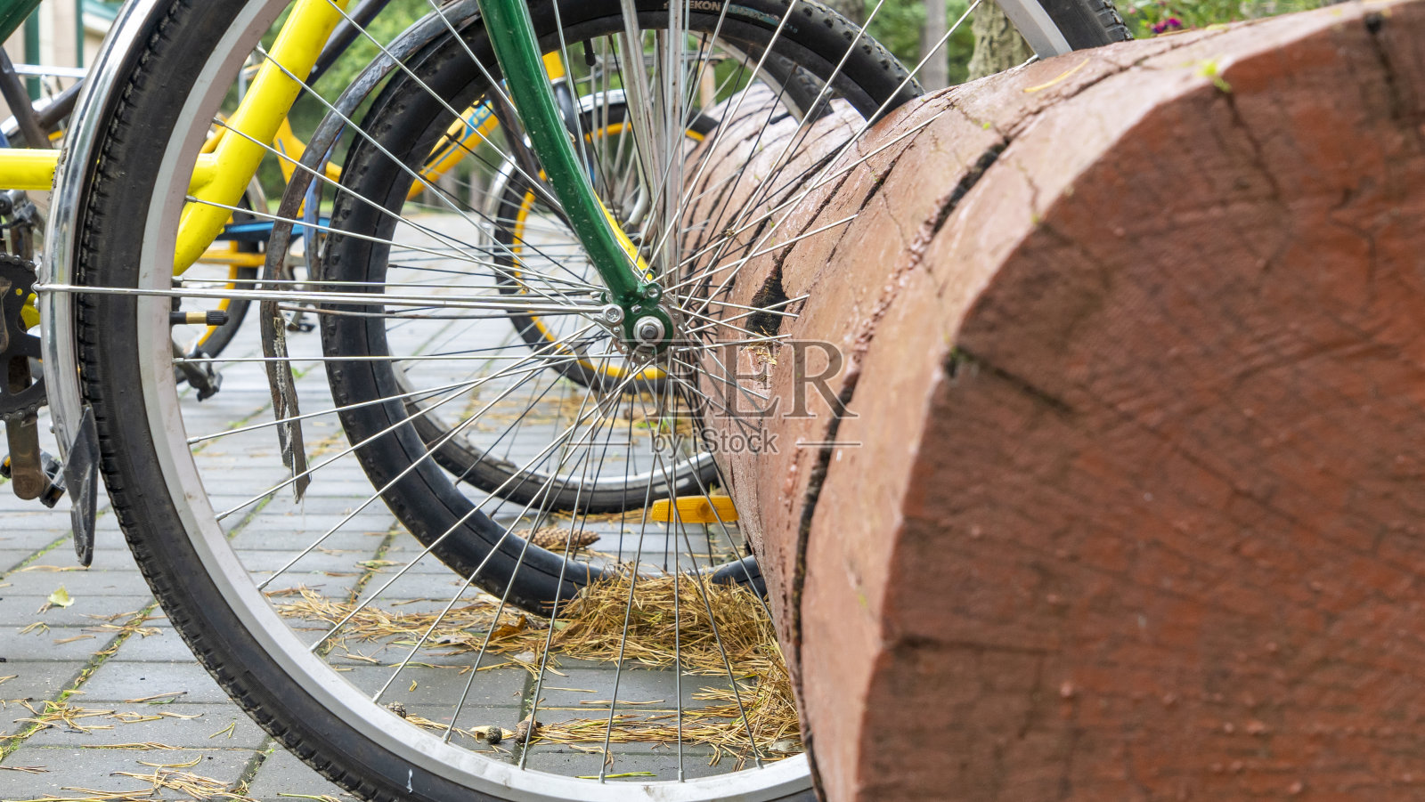 乡村的自行车架。由后备箱制成的自行车停放架。自行车停放处是用一根大圆木做的。照片摄影图片