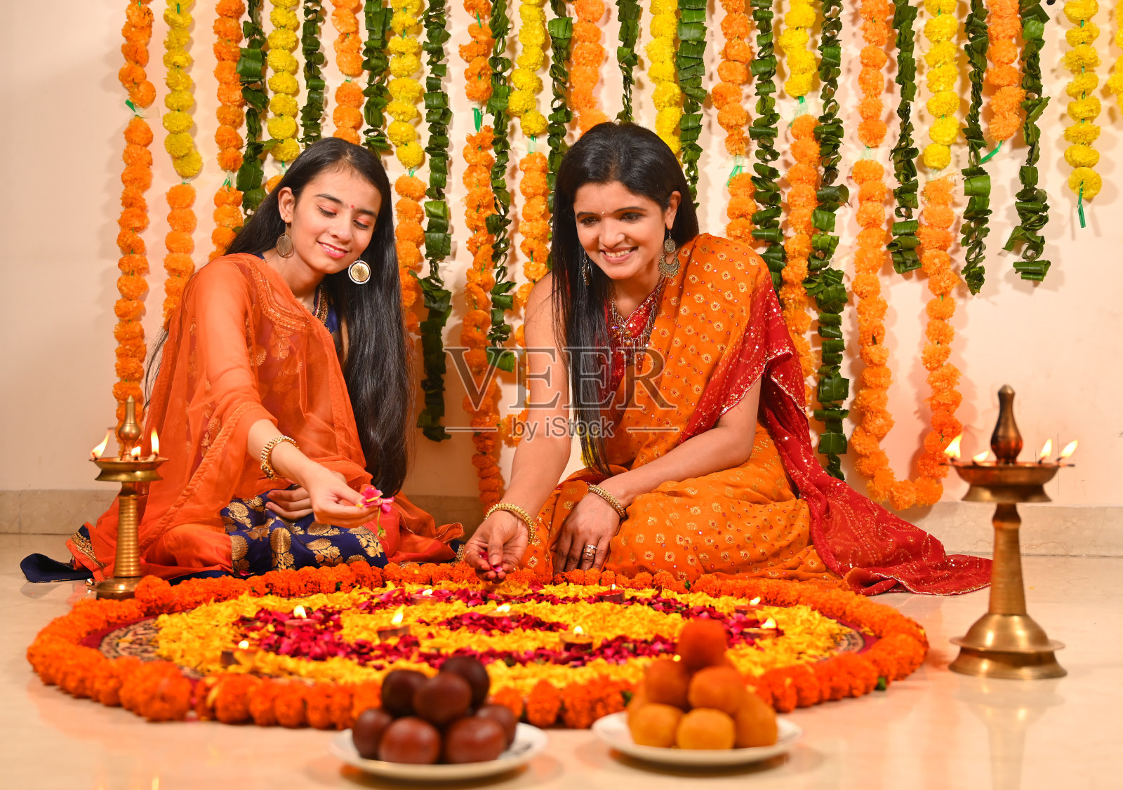 母亲带着女儿在地板上装饰花兰果照片摄影图片