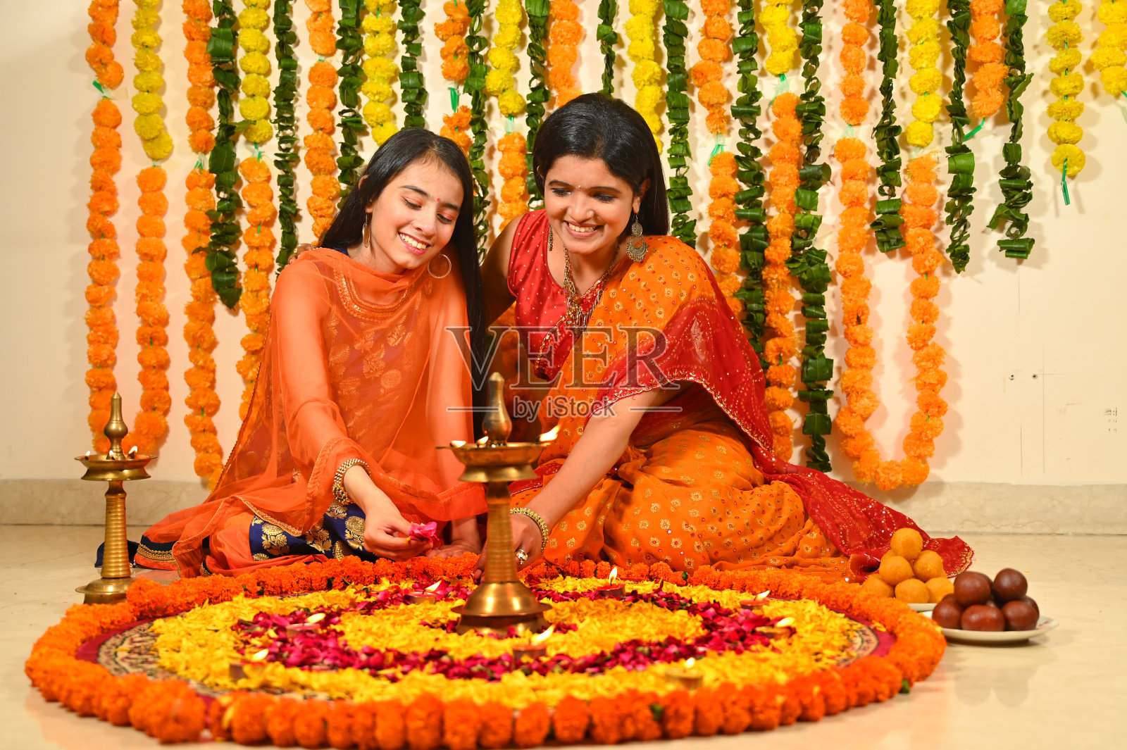 母亲带着女儿在地板上装饰花兰果照片摄影图片