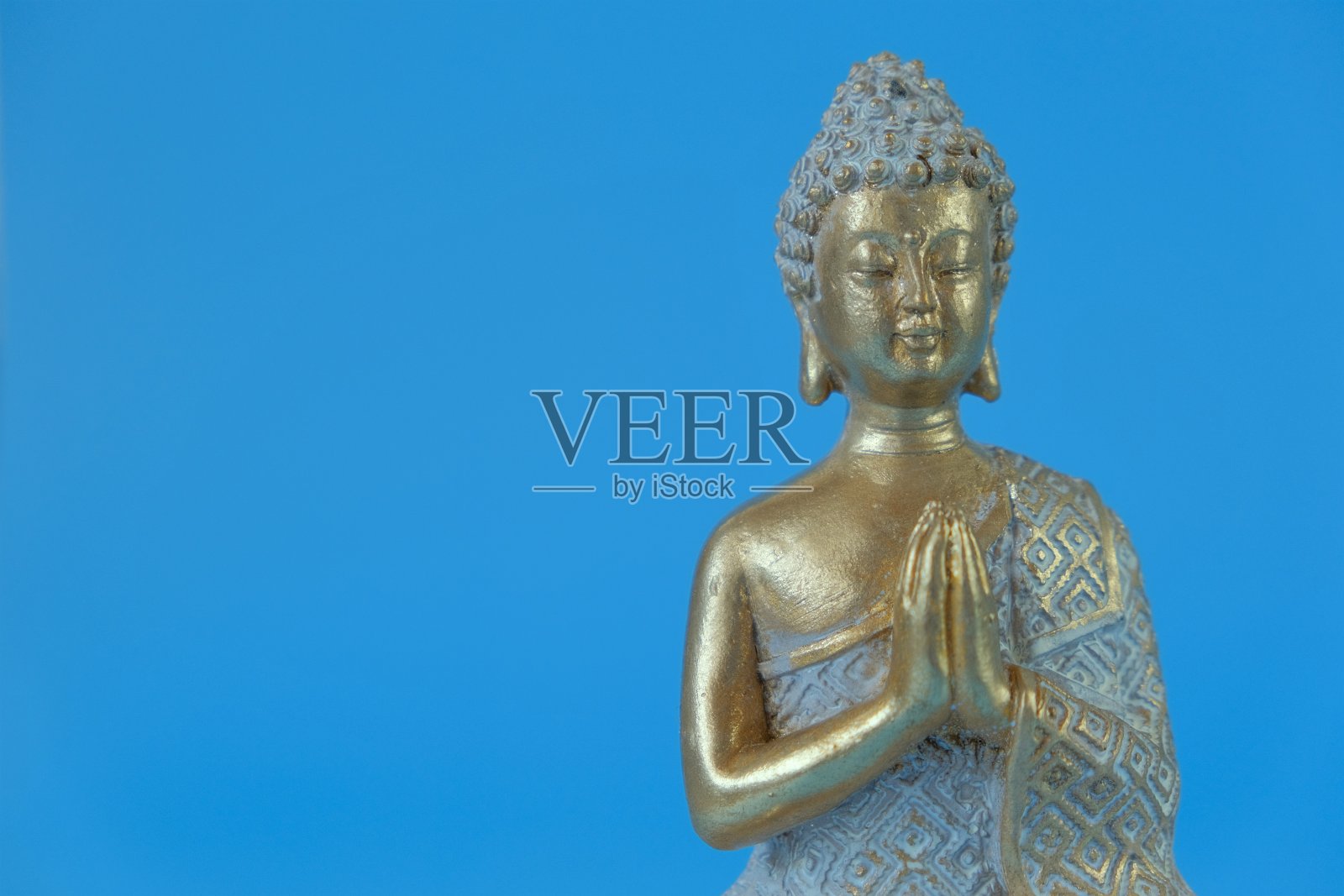 蓝色背景上的佛像。冥想和放松的象征。佛教的宗教背景。佛教信仰的象征。冥想和放松仪式。照片摄影图片