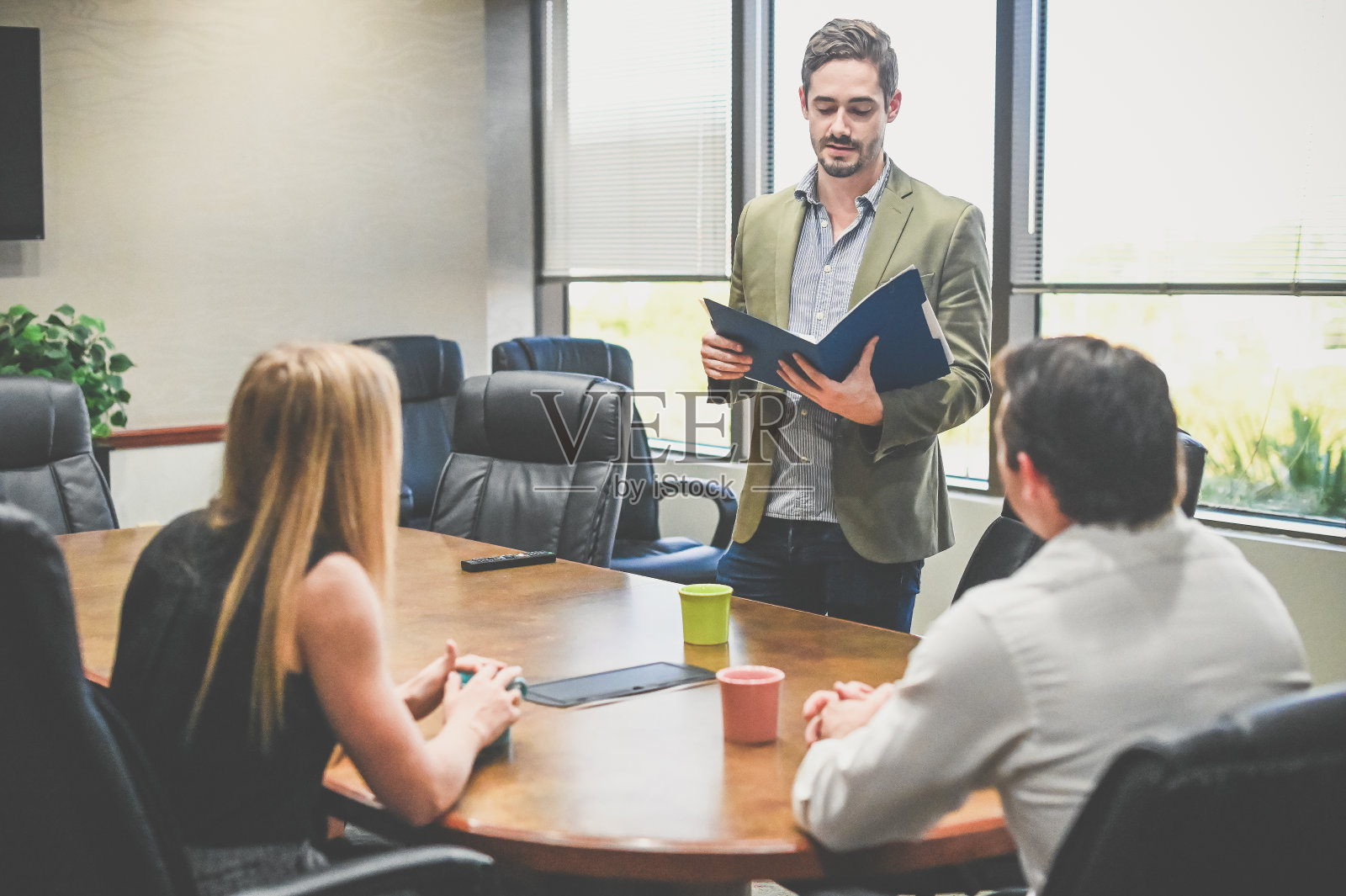 一名男子在会议室向一群同事做演示同事们在开会照片摄影图片