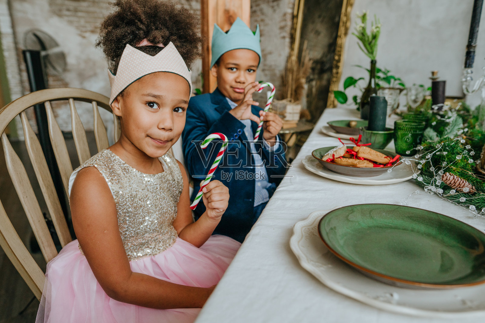 妹妹和弟弟拿着圣诞糖果拐杖照片摄影图片